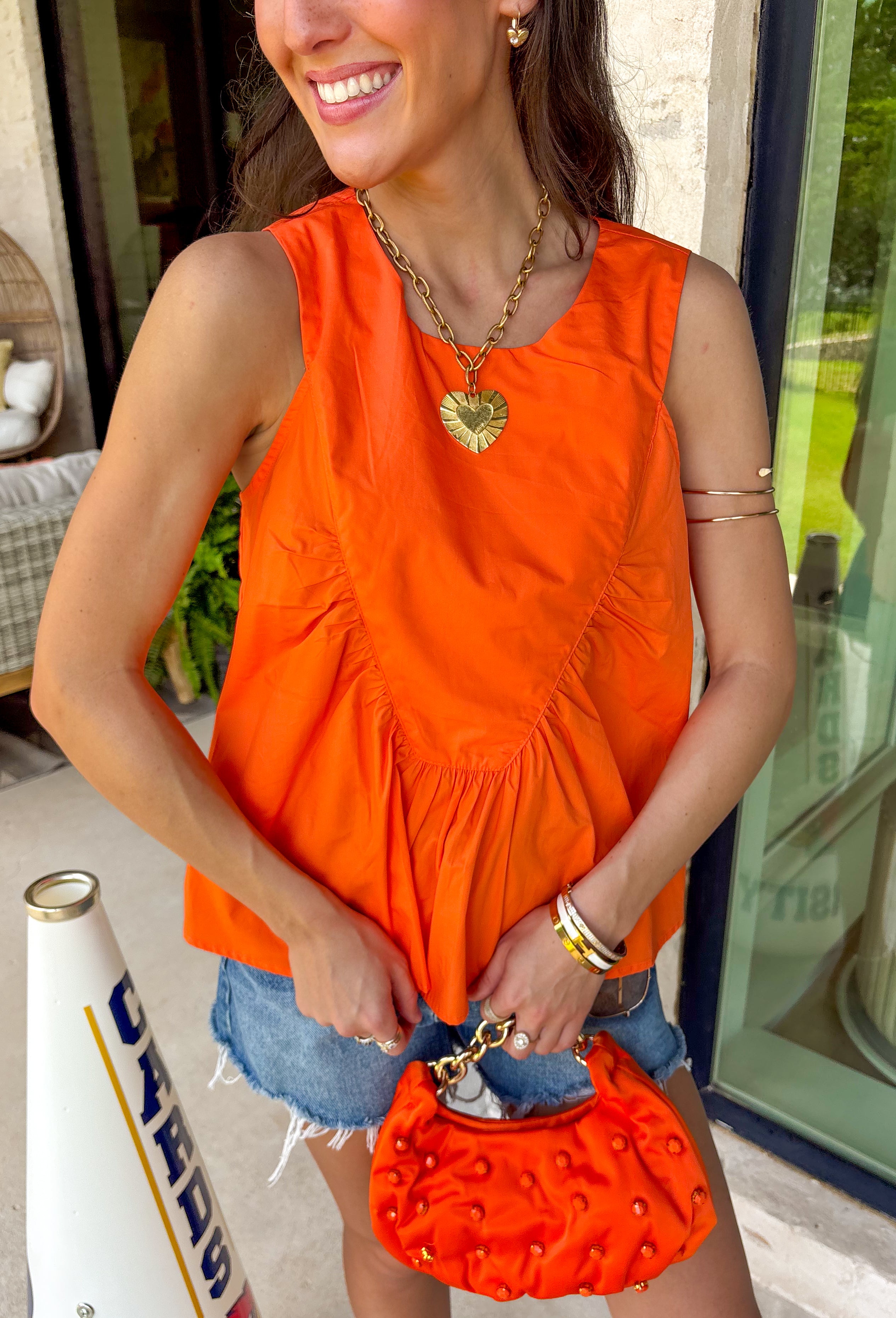 This orange sleeveless top is the versatile staple your wardrobe needs all year long! The vibrant color makes it a standout choice for game day season, while the clean, classic silhouette ensures you'll wear it far beyond football weekends. Designed with a high round neckline and a simple keyhole button closure in the back, it has an elevated look that's easy to dress up or down.