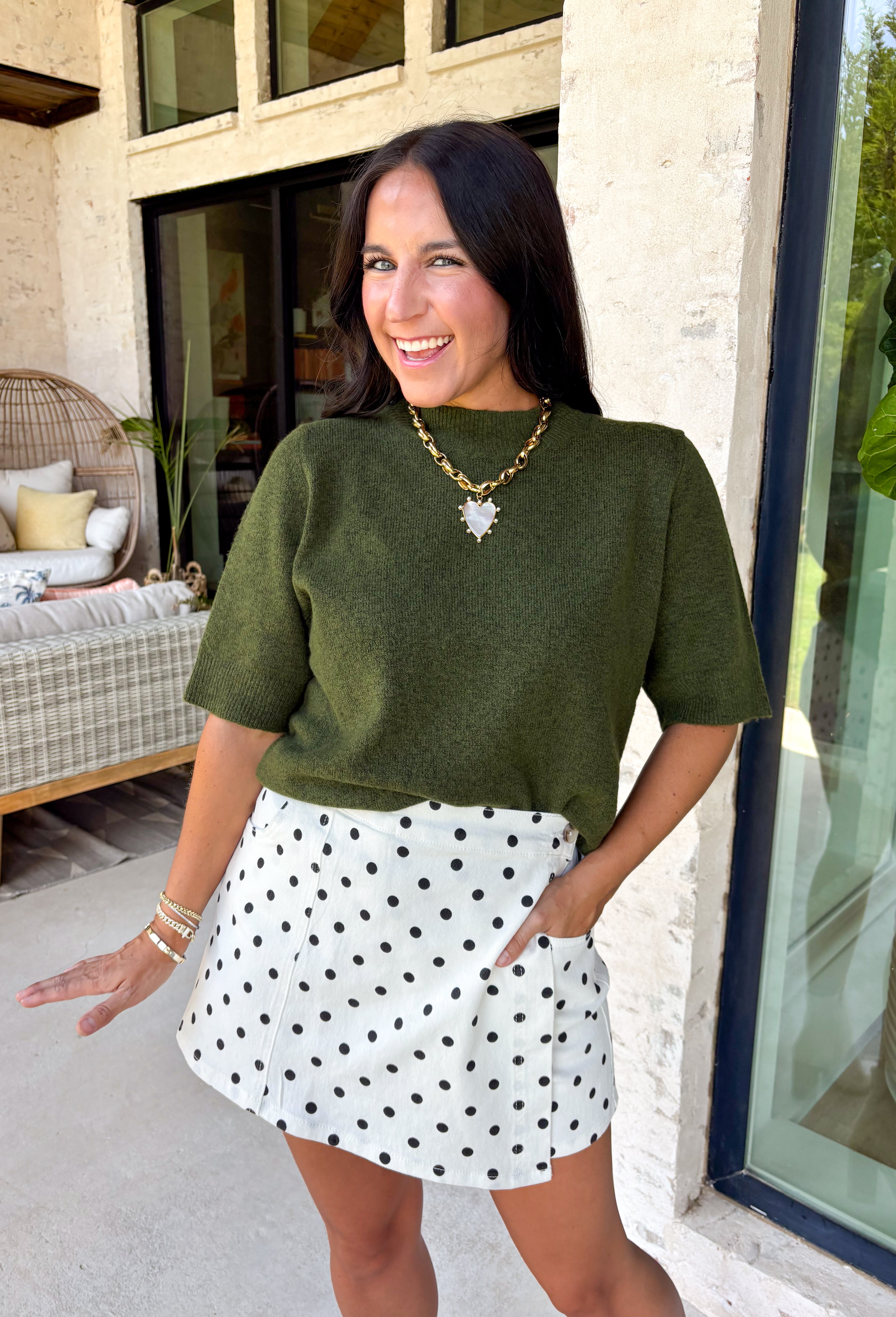 Every fall wardrobe needs a sweater like this! Soft, cozy, and endlessly versatile, this olive mock neck short sleeve sweater is the perfect layering piece for the season. The lightweight knit makes it comfortable enough for warmer autumn afternoons while still providing the cozy feel you'll love as temperatures begin to cool. Finished with a classic mock neckline and ribbed detailing, this timeless sweater pairs effortlessly with everything from your favorite denim to tailored trousers.