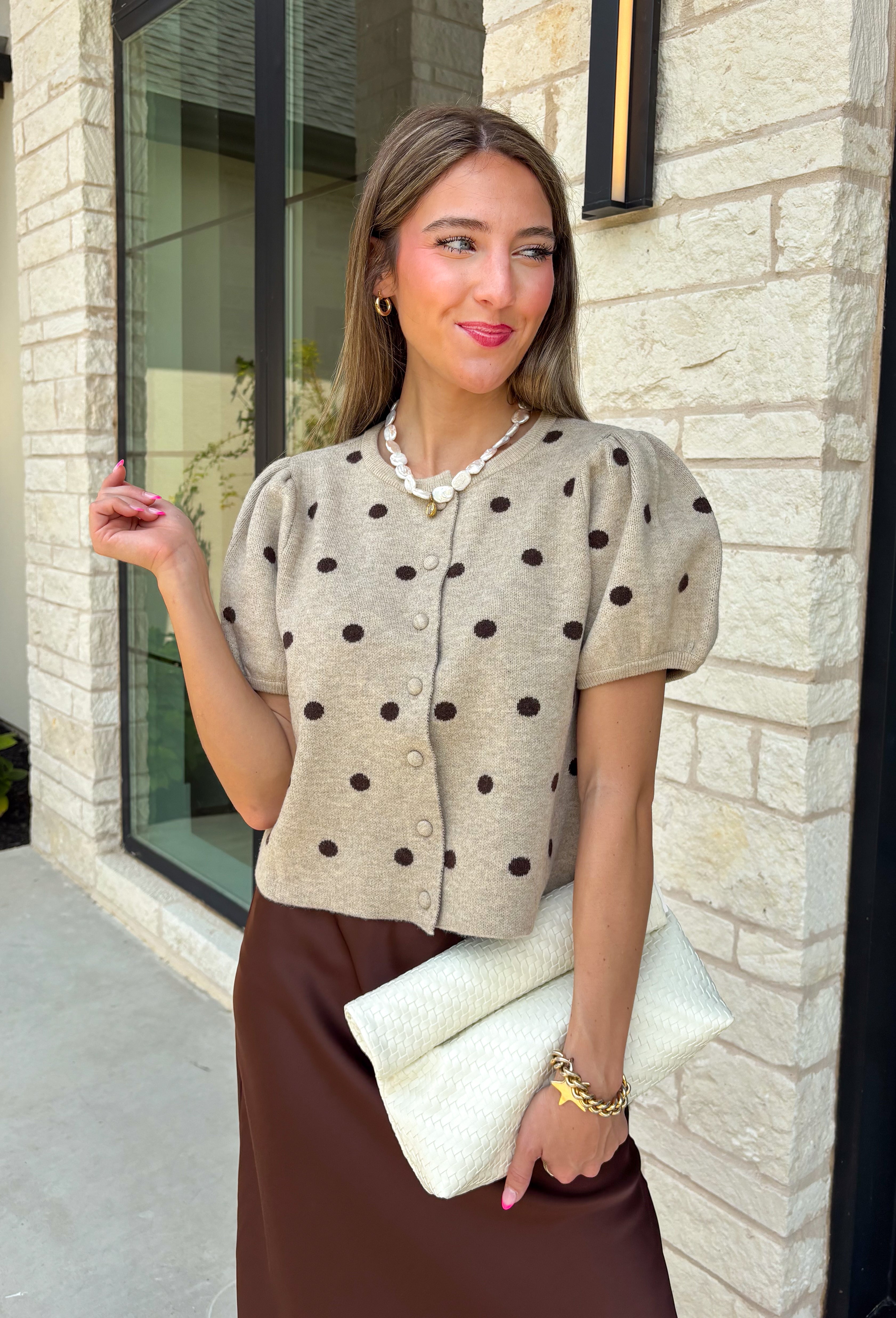 A classic print meets an effortlessly feminine silhouette in this charming knit cardigan! Featuring a soft tan knit with a playful brown polka dot print, this button-down cardigan is finished with sweet puff sleeves for an elevated touch. Whether worn buttoned as a top or layered over your favorite basics, this versatile piece is perfect for everything from office days to coffee dates and weekend outings.