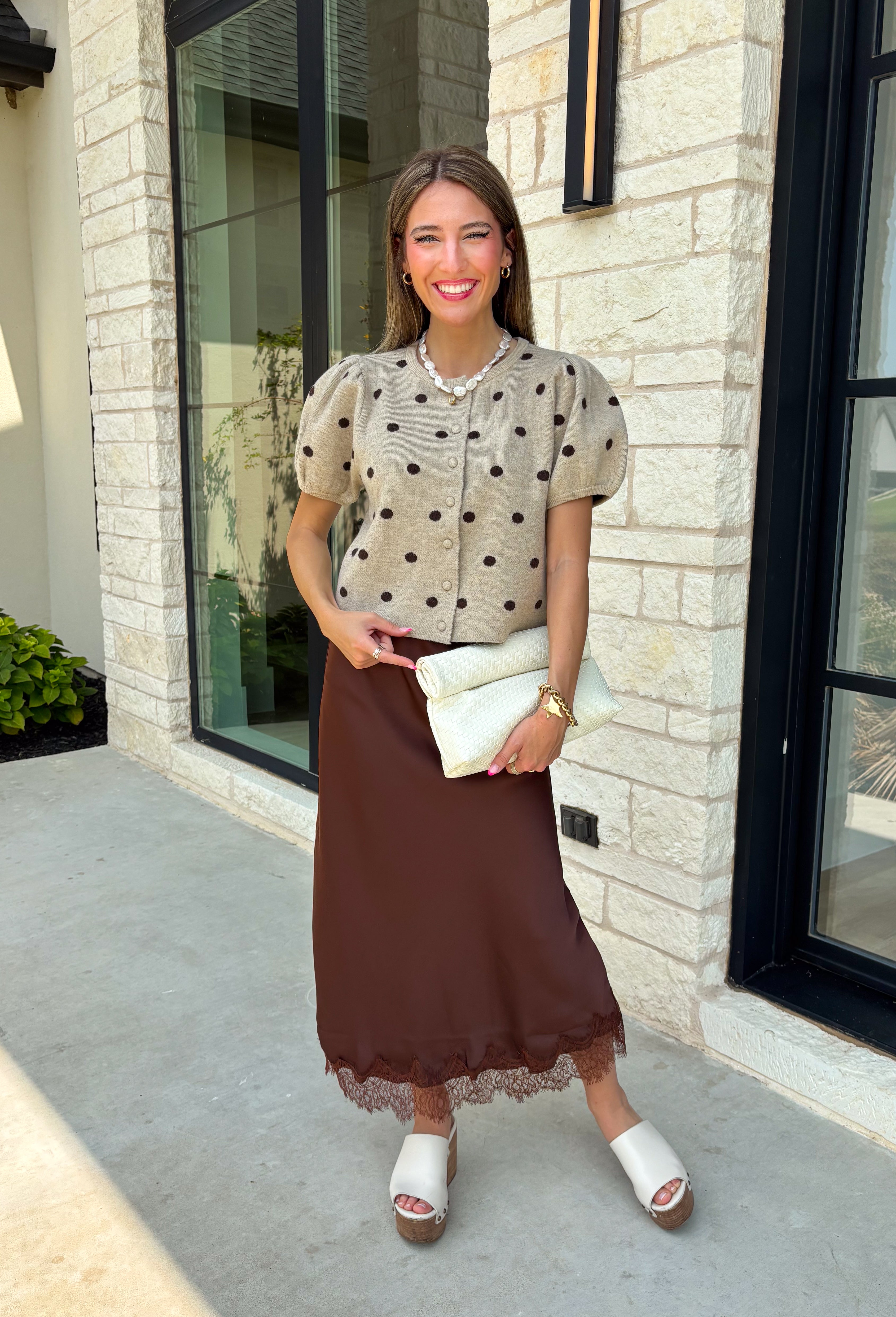 A classic print meets an effortlessly feminine silhouette in this charming knit cardigan! Featuring a soft tan knit with a playful brown polka dot print, this button-down cardigan is finished with sweet puff sleeves for an elevated touch. Whether worn buttoned as a top or layered over your favorite basics, this versatile piece is perfect for everything from office days to coffee dates and weekend outings.