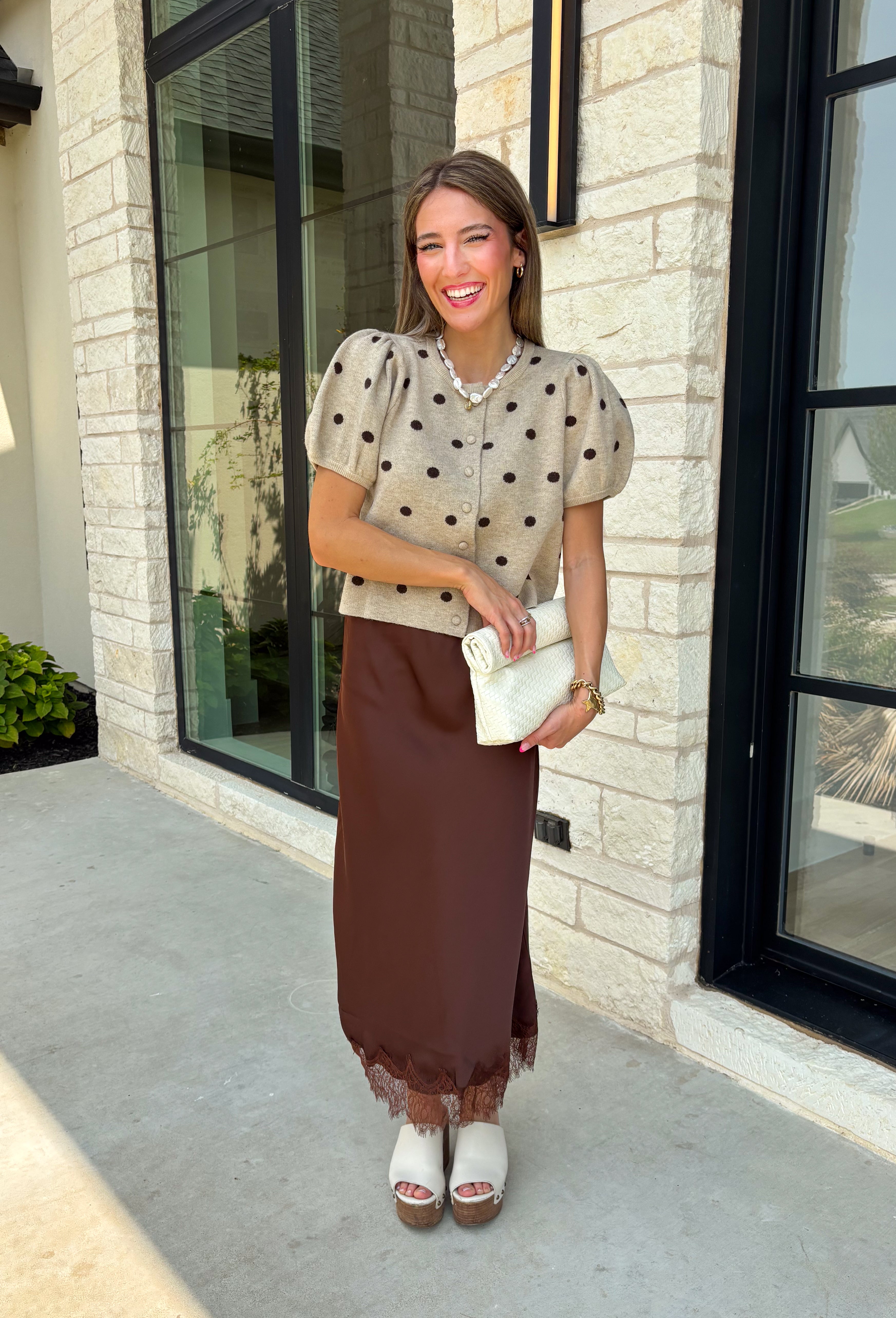 A classic print meets an effortlessly feminine silhouette in this charming knit cardigan! Featuring a soft tan knit with a playful brown polka dot print, this button-down cardigan is finished with sweet puff sleeves for an elevated touch. Whether worn buttoned as a top or layered over your favorite basics, this versatile piece is perfect for everything from office days to coffee dates and weekend outings.