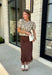Bring a touch of romance to your fall wardrobe with this stunning chocolate brown satin midi skirt. Crafted from silky satin that catches the light beautifully, this chic skirt is finished with a delicate lace hem for an effortlessly feminine look. The elastic waistband offers all-day comfort while the side zipper creates a flattering, polished fit. Whether you're styling it for holiday gatherings, date nights, or elevating your everyday look, this timeless piece is one you'll love season after season.