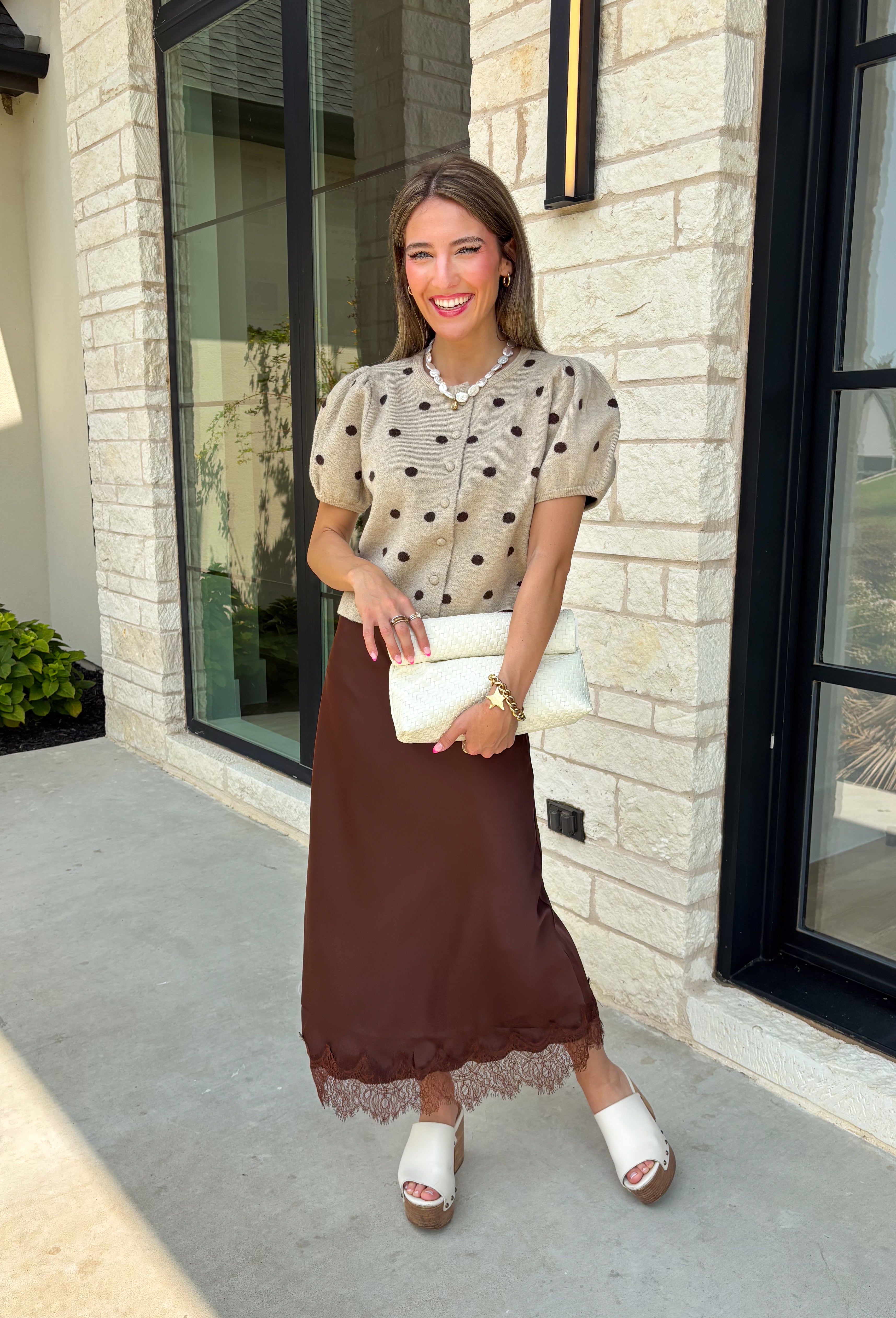 A classic print meets an effortlessly feminine silhouette in this charming knit cardigan! Featuring a soft tan knit with a playful brown polka dot print, this button-down cardigan is finished with sweet puff sleeves for an elevated touch. Whether worn buttoned as a top or layered over your favorite basics, this versatile piece is perfect for everything from office days to coffee dates and weekend outings.