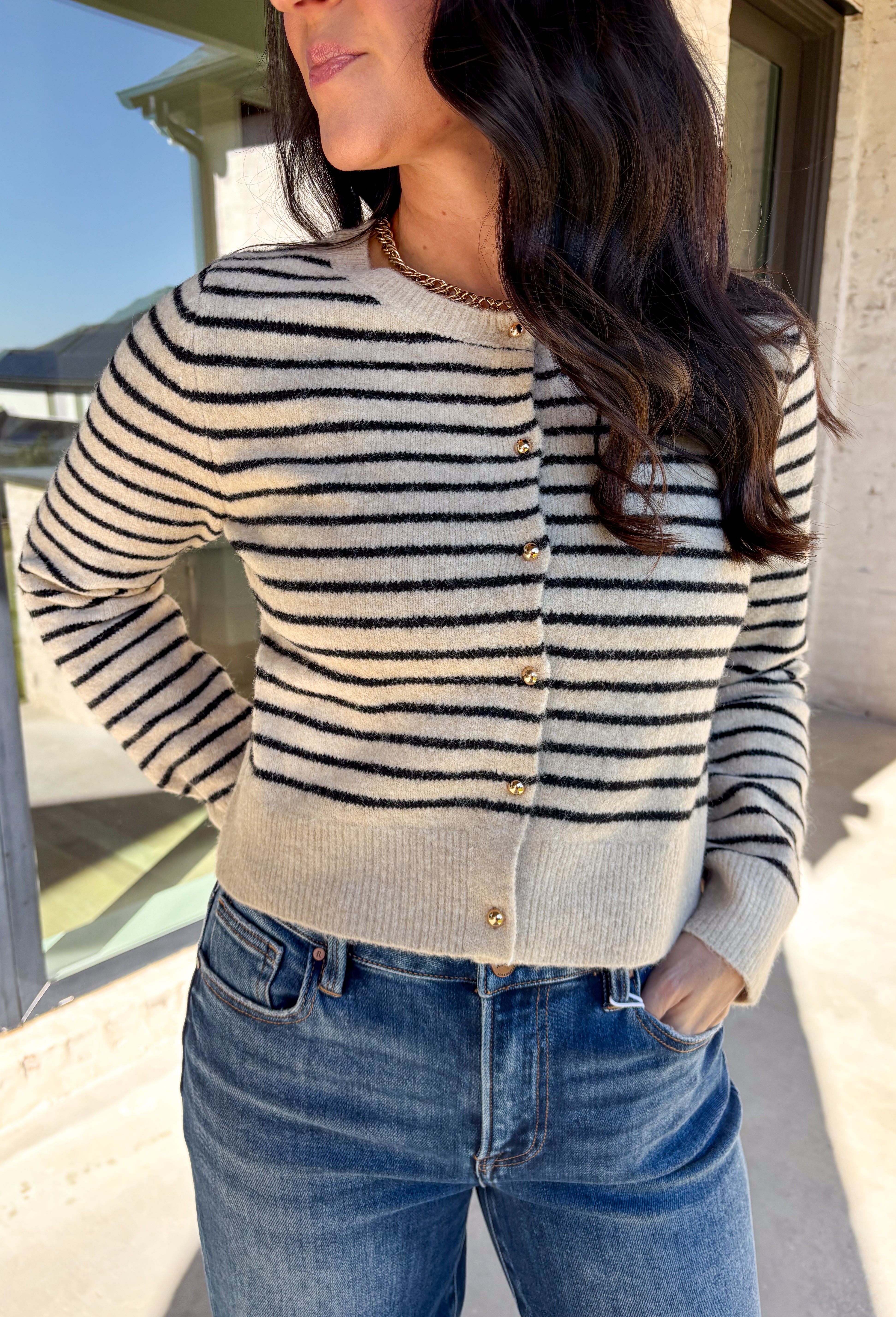 Chic, cozy, and perfect for winter layering, this taupe button-down cardigan by Paper Moon brings a modern twist to a classic stripe. Featuring black stripe detailing and gleaming gold buttons, this cropped knit adds just the right amount of polish to your cold-weather wardrobe. Soft, warm, and easy to style, it’s the ideal piece for dressing up denim or layering over your favorite winter basics.