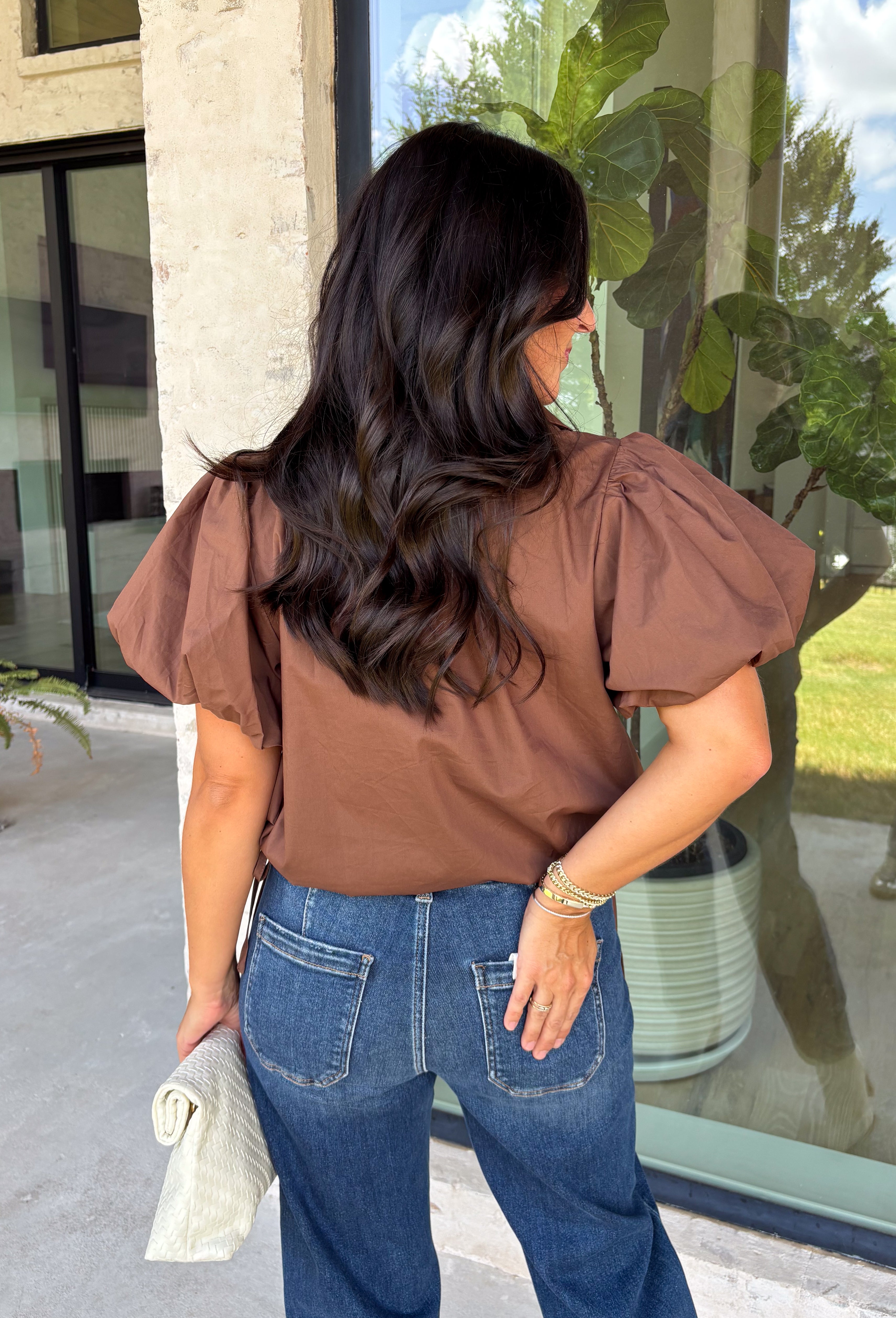 Elevate your everyday wardrobe with this effortlessly polished blouse from Entro. Designed in a rich chocolate brown hue, this timeless top features a classic button-front design with a collared neckline for a sophisticated look. Feminine puff sleeves and charming side tie details add a modern twist, creating a flattering silhouette that's easy to dress up or down. Crafted from breathable cotton, this versatile blouse is perfect for everything from office days to weekend brunches.