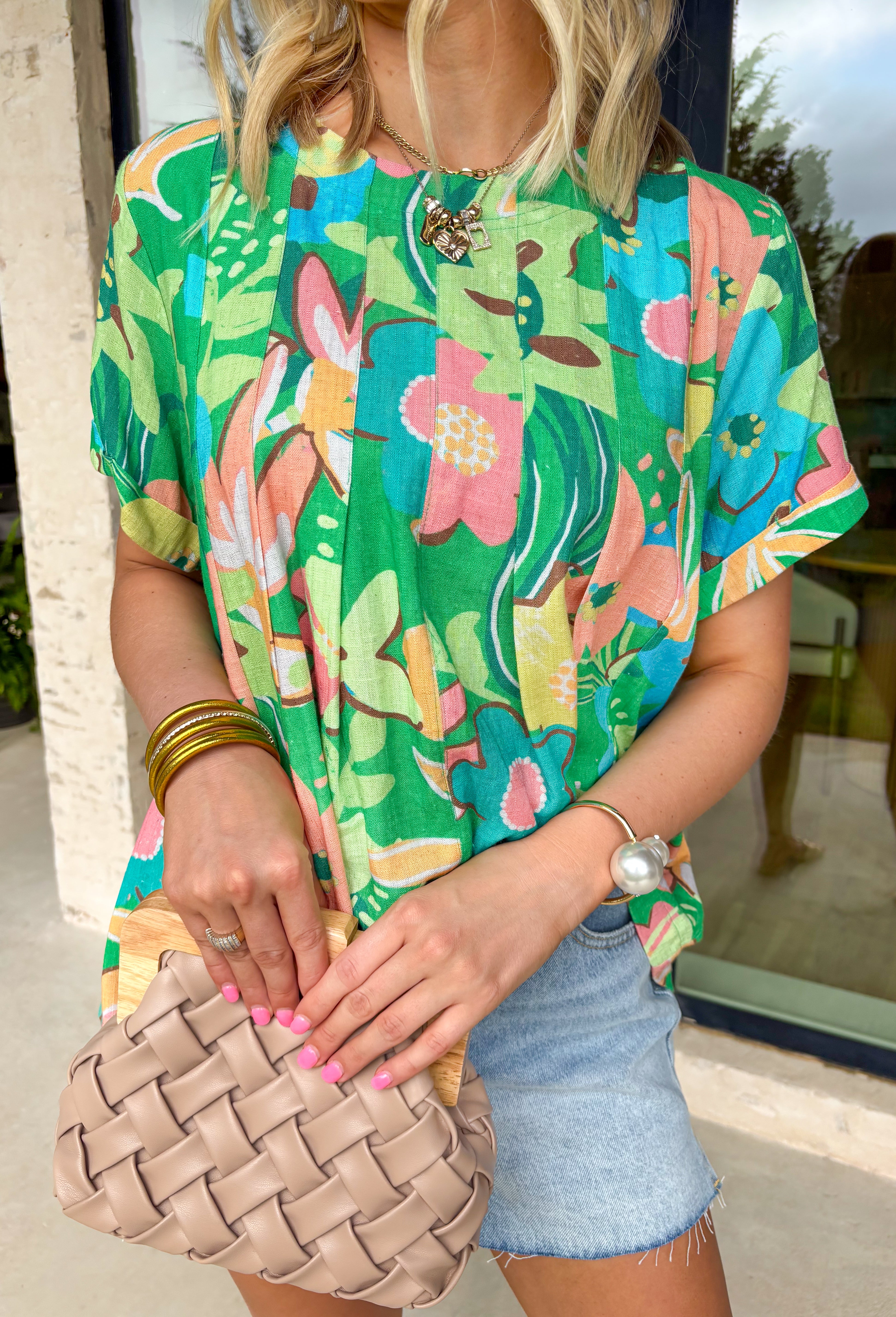 This short sleeve green top is made to brighten up your spring wardrobe with its bold, colorful floral print that truly pops. Featuring a vibrant mix of peach, pink, blue, green, brown, and white, this top feels cheerful, eye-catching, and effortlessly fun. The lightweight linen-blend fabric keeps it breathable and comfortable, while the easy silhouette makes it perfect for everyday wear. It’s the kind of top that instantly lifts your outfit—no extra styling required.