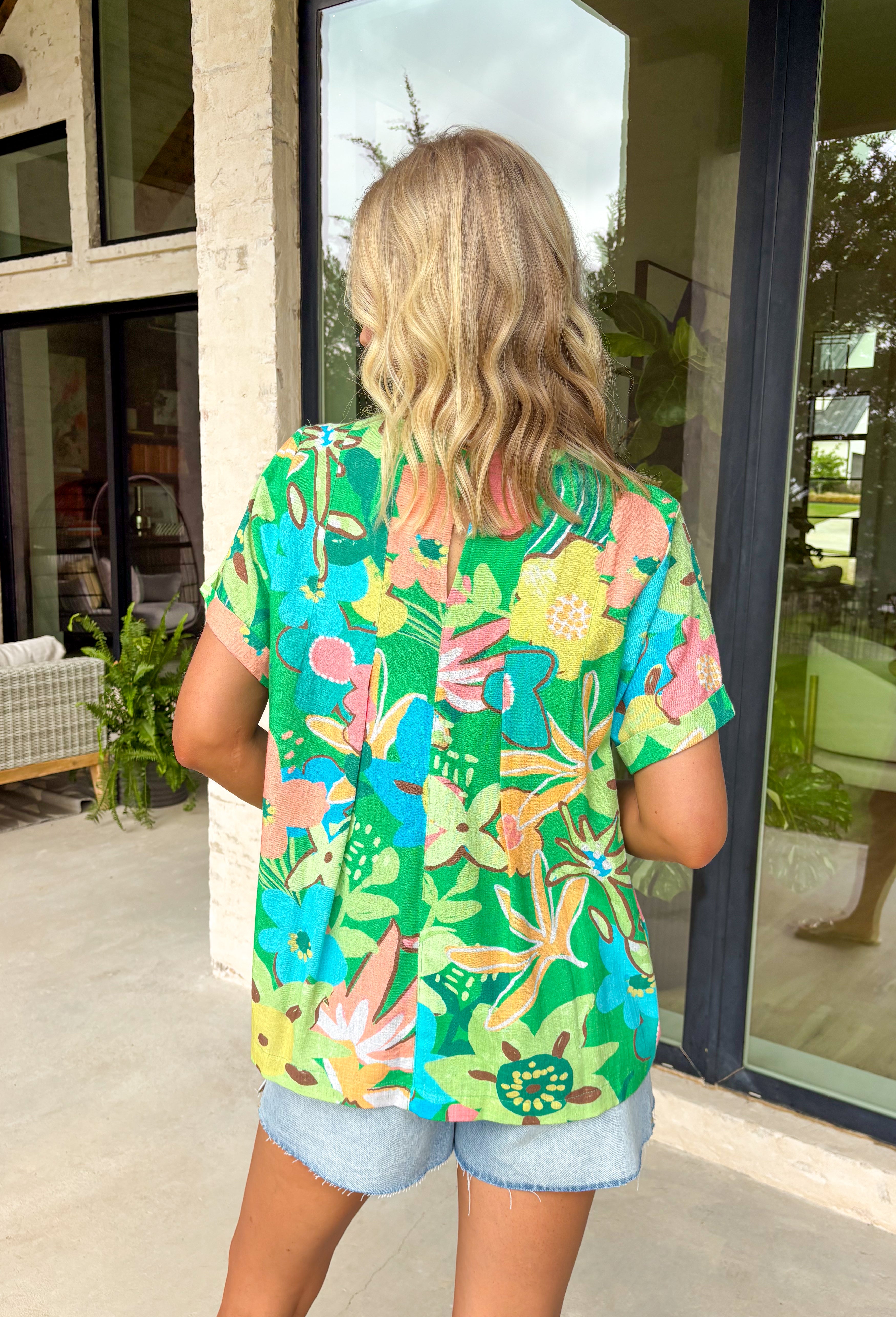 This short sleeve green top is made to brighten up your spring wardrobe with its bold, colorful floral print that truly pops. Featuring a vibrant mix of peach, pink, blue, green, brown, and white, this top feels cheerful, eye-catching, and effortlessly fun. The lightweight linen-blend fabric keeps it breathable and comfortable, while the easy silhouette makes it perfect for everyday wear. It’s the kind of top that instantly lifts your outfit—no extra styling required.
