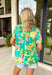 This short sleeve green top is made to brighten up your spring wardrobe with its bold, colorful floral print that truly pops. Featuring a vibrant mix of peach, pink, blue, green, brown, and white, this top feels cheerful, eye-catching, and effortlessly fun. The lightweight linen-blend fabric keeps it breathable and comfortable, while the easy silhouette makes it perfect for everyday wear. It’s the kind of top that instantly lifts your outfit—no extra styling required.