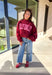 Make your winter wardrobe a little more fun with this playful “Dilly Dally” pullover by Bucket List. Featuring bold hot pink lettering on a rich burgundy backdrop, this cozy mock neck sweatshirt is made for chill days and cheerful moods. With its oversized fit and soft fabric, it’s the perfect mix of comfort and attitude for the season.