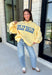 Why choose one look when you can have two? This cozy reversible pullover is full of personality with playful sayings on each side. One side features "Dilly Dally" in blue and white gingham lettering, while the fleece-lined reverse showcases "Lolly Gag" in pink and white gingham for an equally fun look. Designed with an oversized fit and a classic mock neckline, this butter yellow sweatshirt is perfect for slow mornings, coffee runs, travel days, and all your cozy fall adventures.