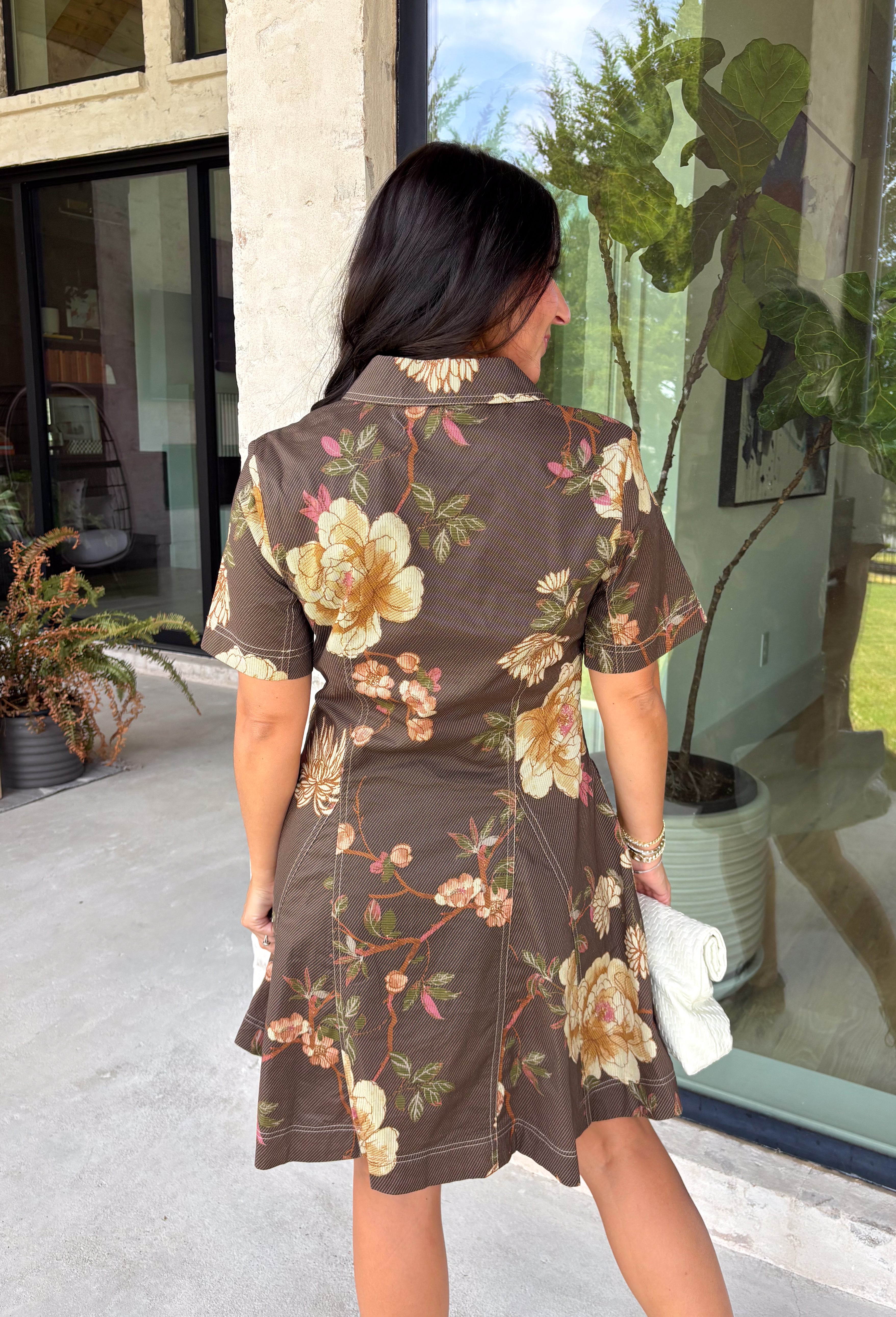 Celebrate the beauty of the season in this effortlessly timeless dress from Entro. Designed in a rich deep olive hue, this button-down dress features a beautiful mix of tan and black stripes paired with a fall-inspired floral print in shades of tan, olive, rust, and brown. The classic button-front silhouette creates an effortlessly polished look, while the fully lined design and convenient side pockets make it as practical as it is beautiful. 