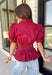 Rich seasonal color and flattering details make this merlot blouse a must-have for fall! Crafted from breathable cotton, this feminine top features a button front, soft puff sleeves, and a flattering tie waist that beautifully defines your silhouette. Pleating at the waist adds a polished touch, while the smocked back provides all-day comfort and the perfect fit. 
