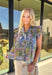 Bright, cheerful, and full of spring charm, this pretty blue short sleeve top by Entro is an instant favorite. Featuring a colorful floral print with pops of green, purple, orange, and yellow, it brings a fun burst of color to your everyday look. The button-down front is accented with pleated trim and soft pleating along the front for a flattering drape, while the pleated ruffle sleeves add the sweetest feminine finish. Made from breathable cotton, this top is perfect for sunny days, brunch plans, and every