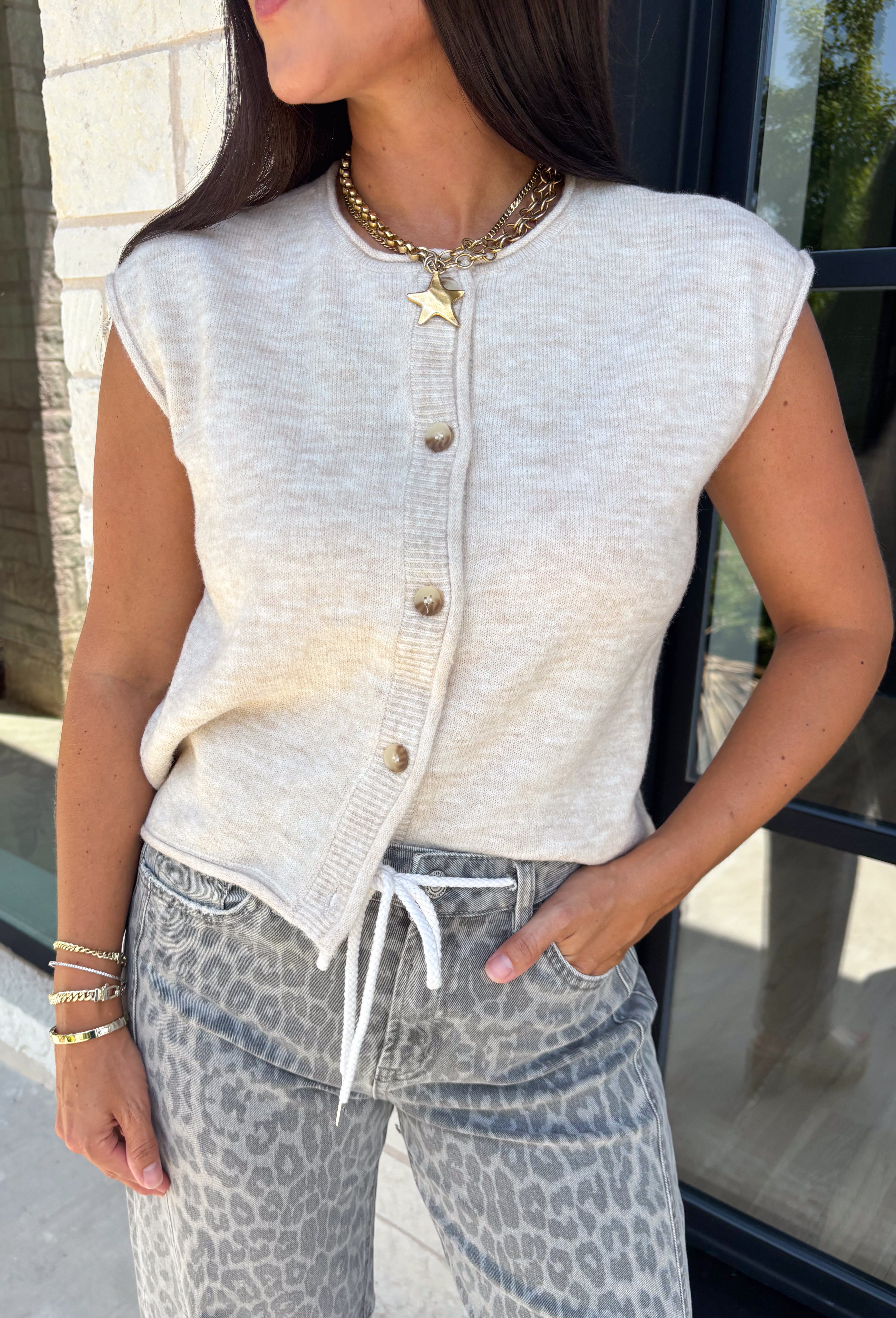 The perfect layering piece for fall has arrived! This oatmeal sleeveless button-down cardigan is a timeless staple you'll reach for again and again. Crafted from a soft, lightweight knit, it's cozy without feeling bulky, making it perfect for layering over dresses, fitted tees, or long sleeve tops as the weather cools. Whether you wear it buttoned as a sweater vest or open for a relaxed layered look, this versatile knit is an effortless addition to your autumn wardrobe.