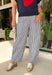 Easy, breezy, and effortlessly put-together! These navy and white stripe barrel pants bring a fresh, coastal-inspired feel to your everyday style. The relaxed barrel silhouette gives them a modern edge, while the classic stripe print keeps them timeless and easy to pair with anything. Subtle metal grommet details add just the right touch of interest, giving these pants a slightly elevated feel. Designed with an elastic waistband, they’re as comfortable as they are stylish—perfect for all-day wear.