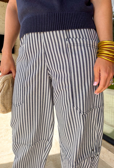 Easy, breezy, and effortlessly put-together! These navy and white stripe barrel pants bring a fresh, coastal-inspired feel to your everyday style. The relaxed barrel silhouette gives them a modern edge, while the classic stripe print keeps them timeless and easy to pair with anything. Subtle metal grommet details add just the right touch of interest, giving these pants a slightly elevated feel. Designed with an elastic waistband, they’re as comfortable as they are stylish—perfect for all-day wear.