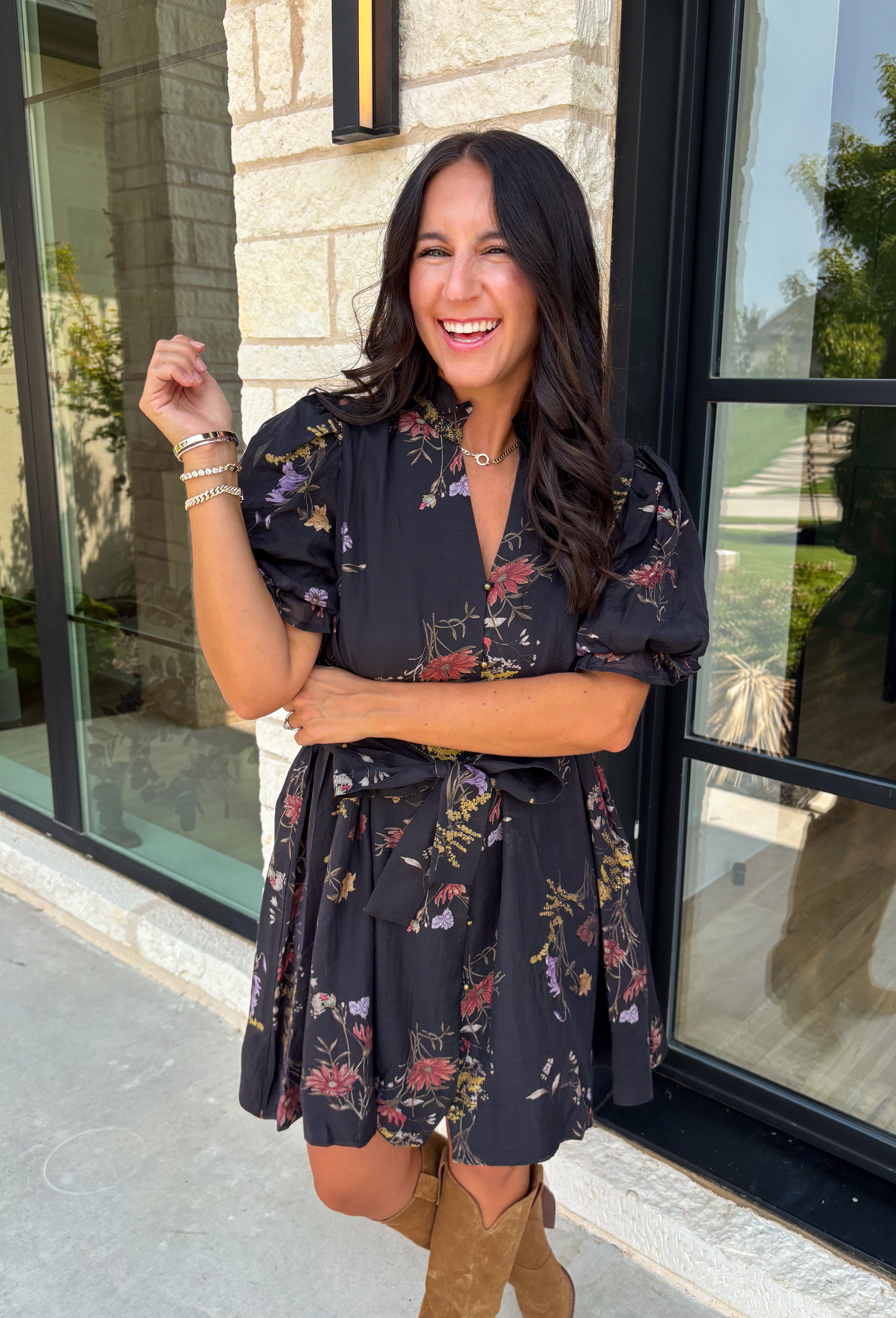 Embrace the beauty of the season in this effortlessly feminine floral dress that's made for all your favorite fall occasions. Designed with a classic black backdrop and adorned with a rich floral print in gorgeous autumn-inspired hues, this dress is the perfect combination of timeless elegance and everyday comfort. The ruffled v-neckline and puff sleeves add a romantic touch, while the self-tie waist creates a flattering silhouette you'll love. 