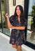 Embrace the beauty of the season in this effortlessly feminine floral dress that's made for all your favorite fall occasions. Designed with a classic black backdrop and adorned with a rich floral print in gorgeous autumn-inspired hues, this dress is the perfect combination of timeless elegance and everyday comfort. The ruffled v-neckline and puff sleeves add a romantic touch, while the self-tie waist creates a flattering silhouette you'll love. 
