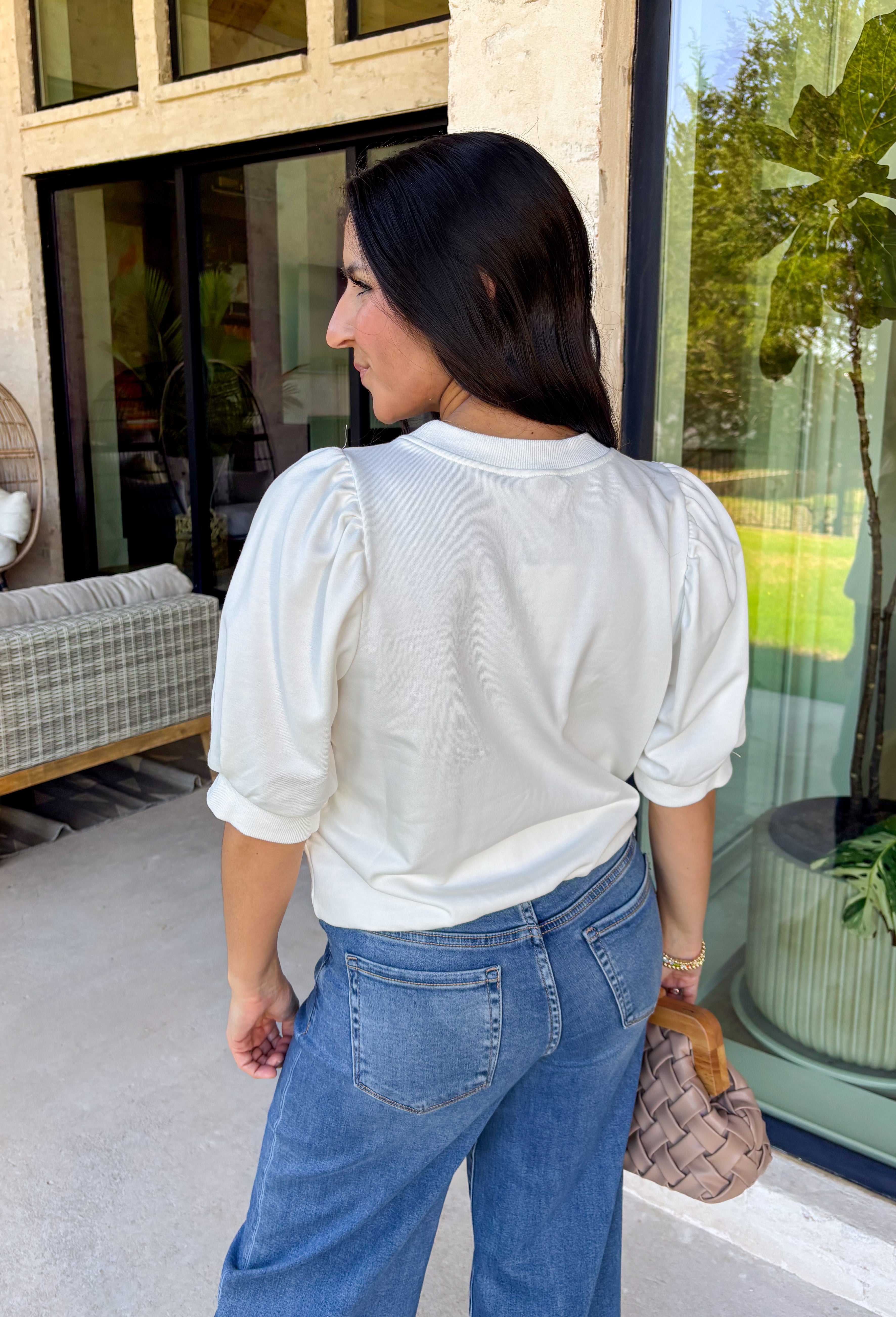 This white short sleeve top is a beautiful blend of soft texture and thoughtful detail, perfect for easy spring styling. The puff sleeves add a touch of volume and femininity, while the tan embroidery along the front creates a warm, eye-catching contrast. Delicate mesh detailing on the front adds dimension and an elevated finish, making this top feel extra special without being fussy. Lightweight and breathable, it’s an effortless piece you can dress up or keep casual all season long.