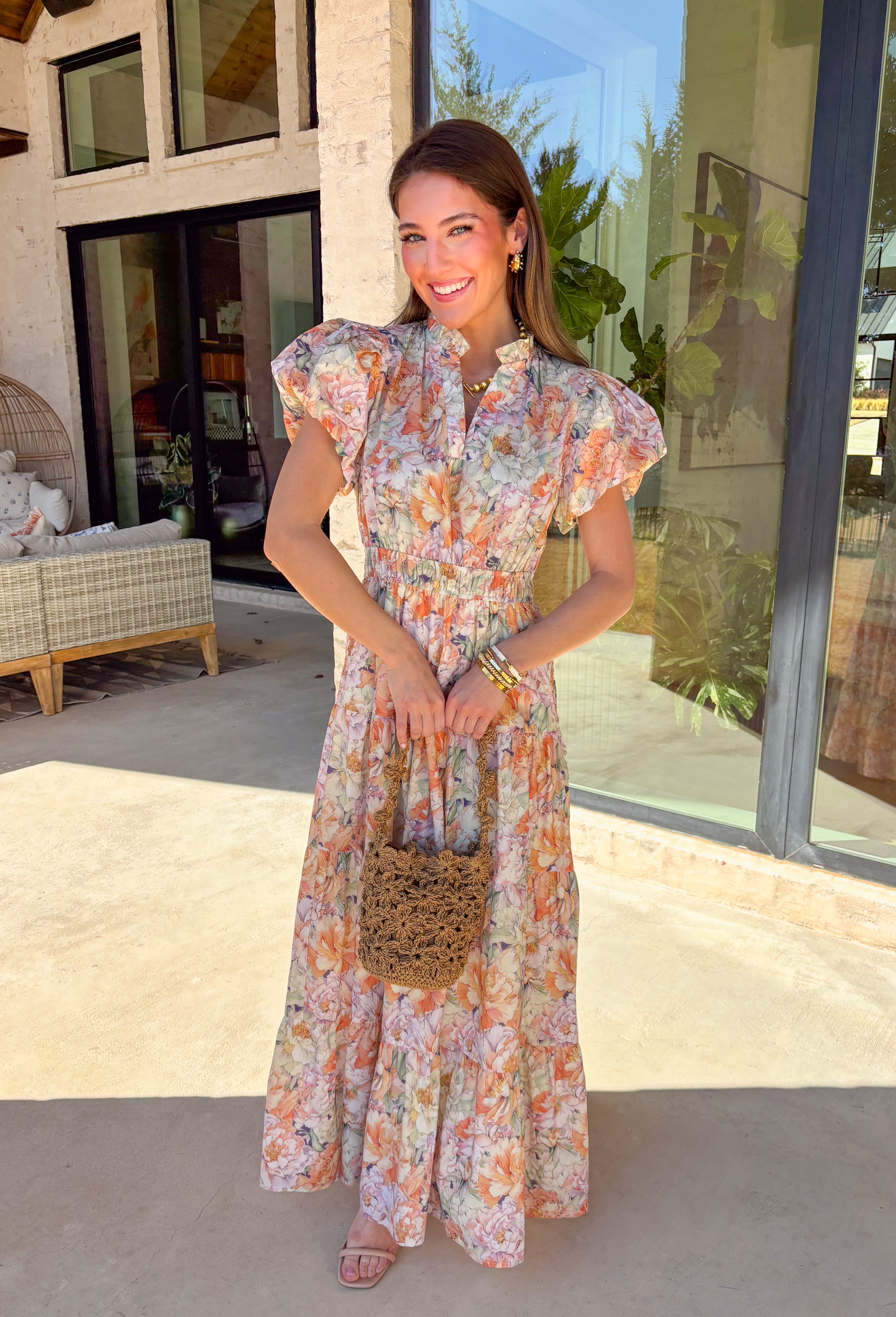 Soft, romantic, and made for spring days, this pastel floral maxi dress by Entro is as easy as it is pretty. Featuring a light, airy floral print in soft spring hues, this dress flows beautifully with its tiered skirt and flattering elastic waist. The subtle ruffle neckline and v-neckline add a delicate touch, while the puff sleeves bring just the right amount of charm. Fully lined and crafted from breathable cotton, it’s perfect for everything from brunch to spring celebrations.