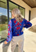 Brighten chilly days with this stunning royal blue turtleneck sweater by Voy. Adorned with a bold floral print in shades of red, blue, white, and burgundy, this cozy knit brings a cheerful pop of color to your winter wardrobe. The soft fabric blend offers both warmth and comfort, making it perfect for layering or wearing on its own for a statement cold-weather look.