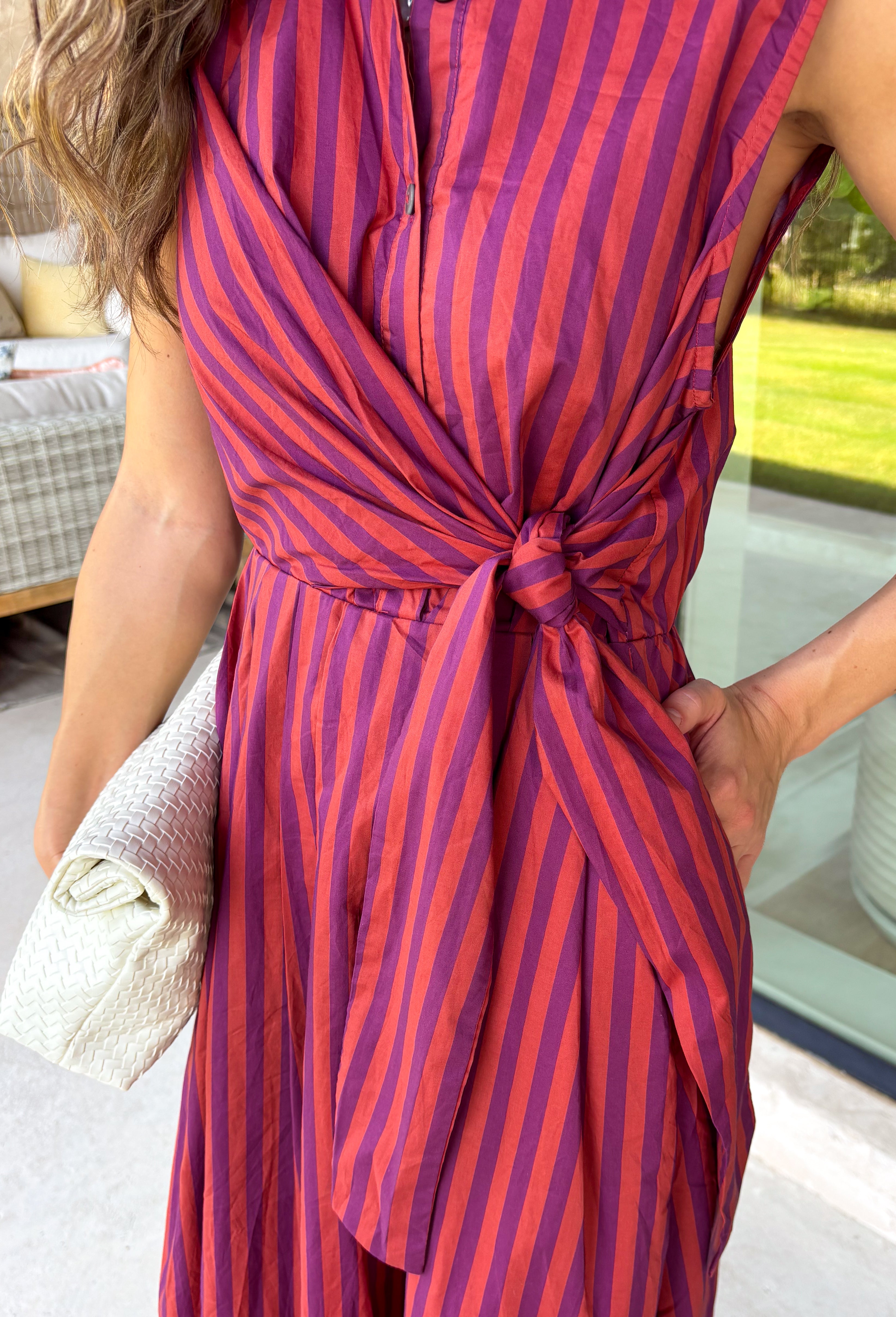 Bring effortless charm to your fall wardrobe with this beautifully detailed midi dress from Entro. Featuring rich plum and rust stripes, this timeless dress combines classic style with feminine touches you'll love. The collared neckline and button-front design create a polished silhouette, while the self-tie detail at the front adds a flattering, playful finish. 
