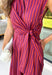 Bring effortless charm to your fall wardrobe with this beautifully detailed midi dress from Entro. Featuring rich plum and rust stripes, this timeless dress combines classic style with feminine touches you'll love. The collared neckline and button-front design create a polished silhouette, while the self-tie detail at the front adds a flattering, playful finish. 