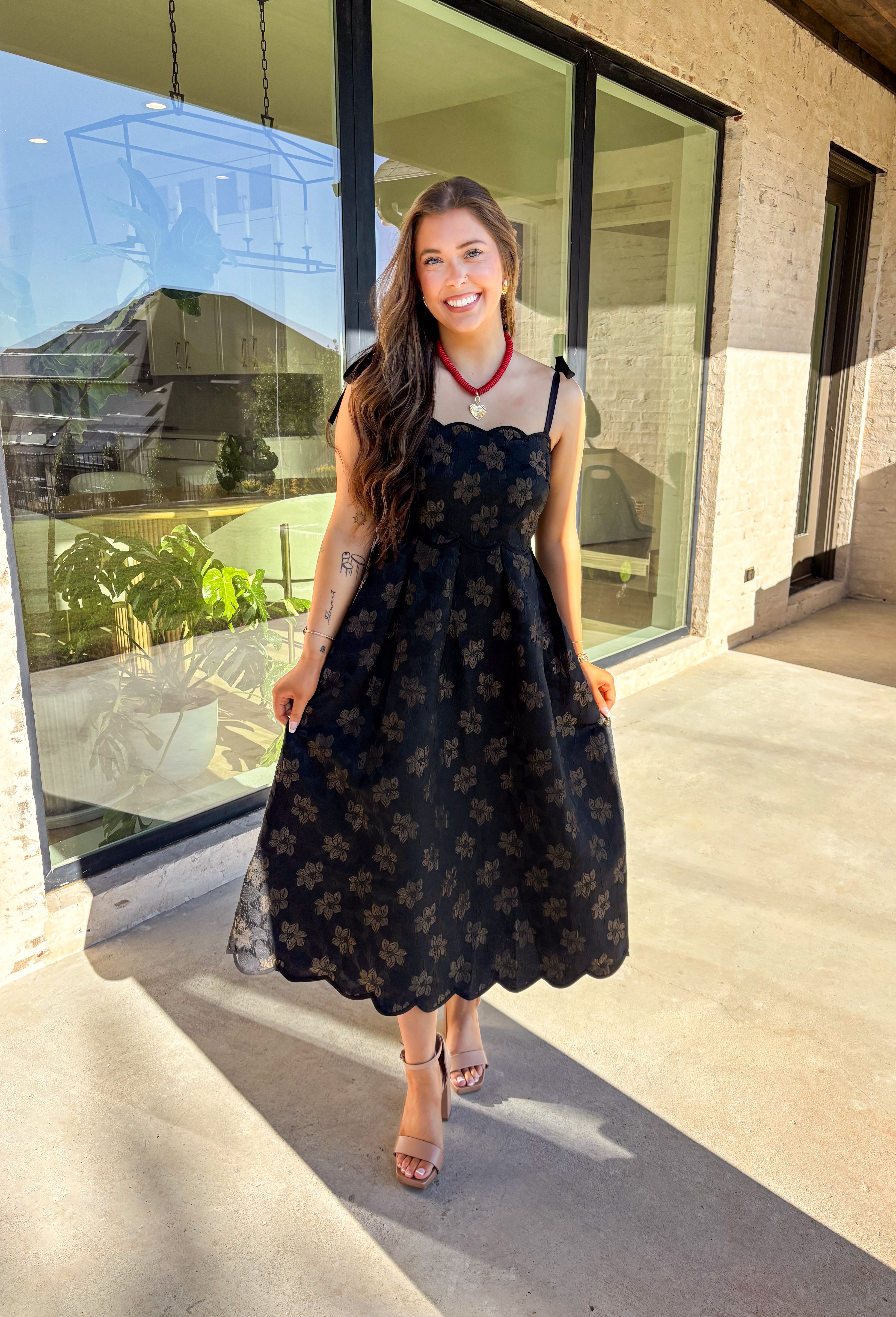 When the invite calls for dressy but you still want to feel comfortable, this is the dress. In classic black with a subtle gold floral texture that feels lace-like, it’s a showstopper without being over the top. The scalloped neckline and hem add a romantic finish, while the self-tie straps let you adjust for the perfect fit. Whether you’re attending a wedding, holiday party, or a candlelit dinner, this midi is a timeless choice you’ll wear for seasons to come.