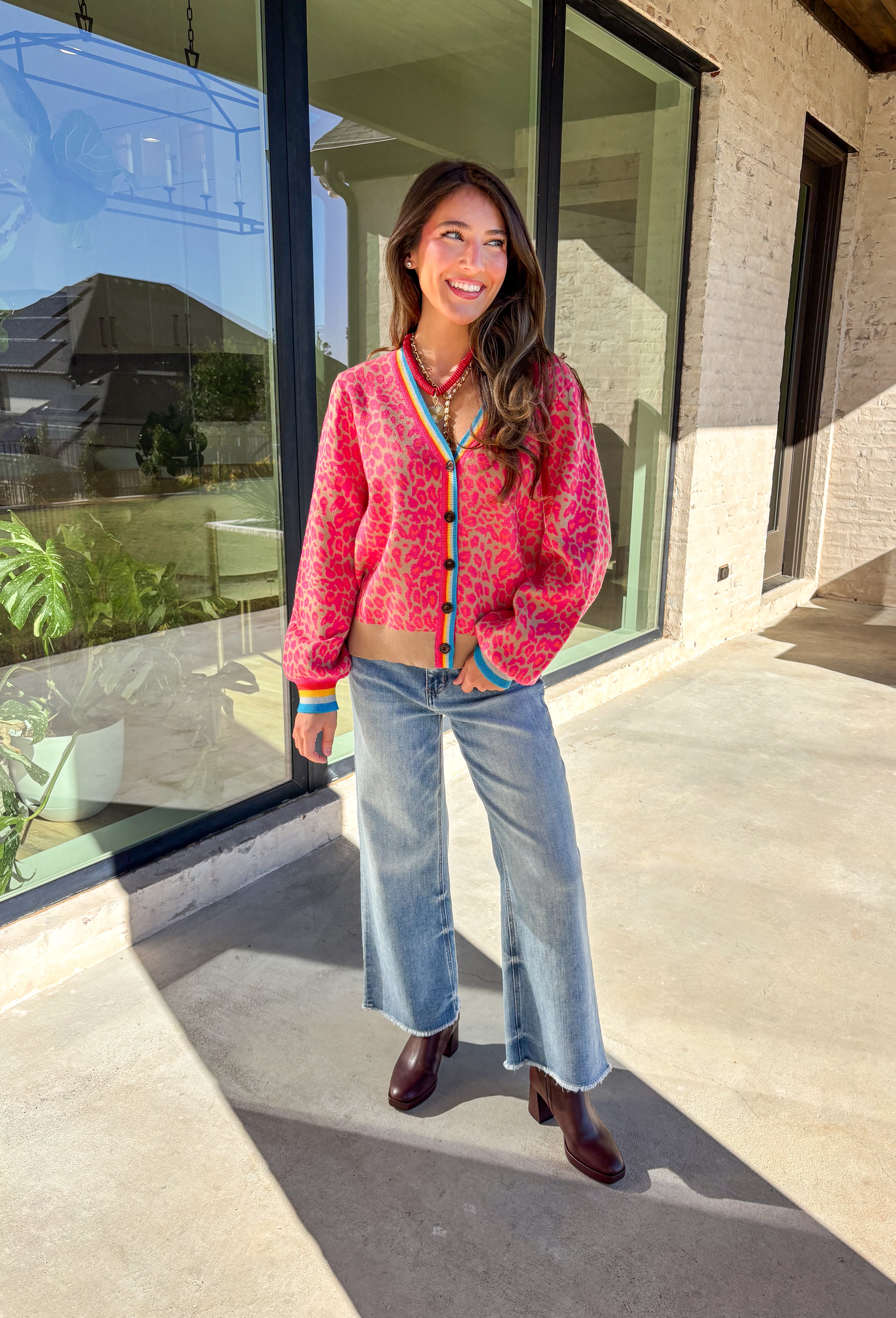 Get ready to turn heads and break up those neutral fall layers with a pop of wild color. This button-down leopard cardigan takes cozy to the next level with its bold pink print on a soft tan background—perfect for making your everyday denim look feel instantly exciting. The colorful trim adds even more personality, making this the ultimate statement layering piece.
