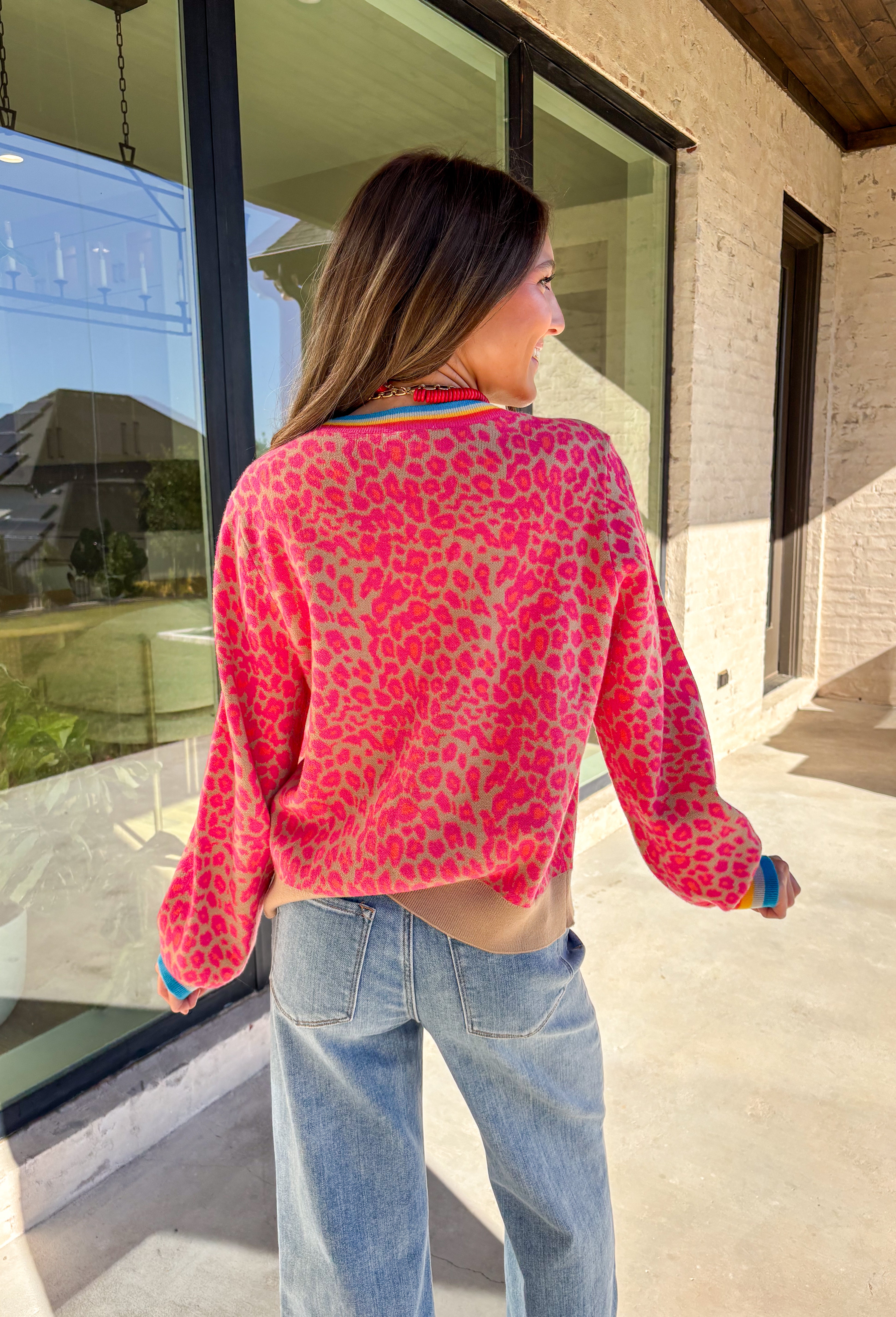 Get ready to turn heads and break up those neutral fall layers with a pop of wild color. This button-down leopard cardigan takes cozy to the next level with its bold pink print on a soft tan background—perfect for making your everyday denim look feel instantly exciting. The colorful trim adds even more personality, making this the ultimate statement layering piece.