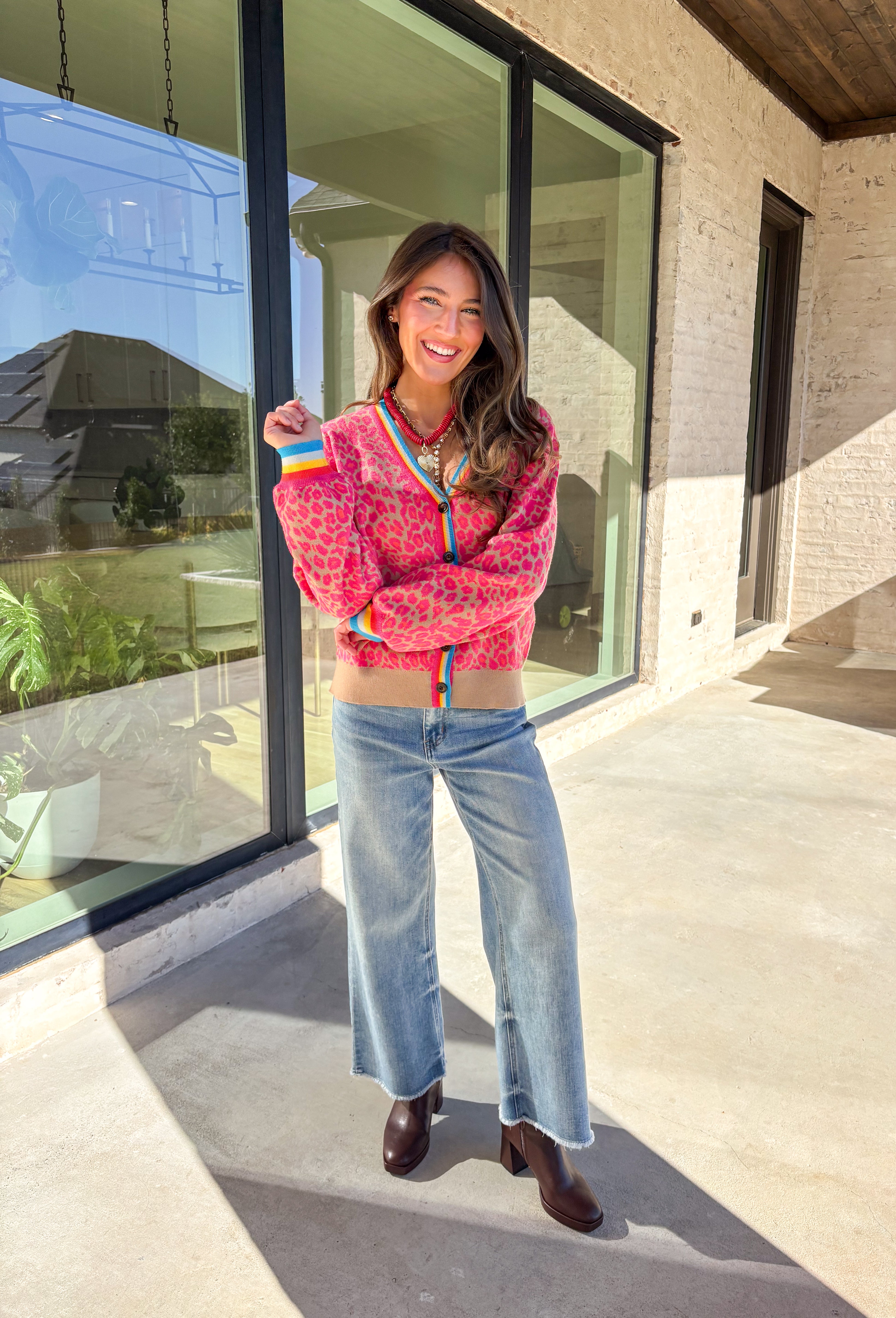 Get ready to turn heads and break up those neutral fall layers with a pop of wild color. This button-down leopard cardigan takes cozy to the next level with its bold pink print on a soft tan background—perfect for making your everyday denim look feel instantly exciting. The colorful trim adds even more personality, making this the ultimate statement layering piece.
