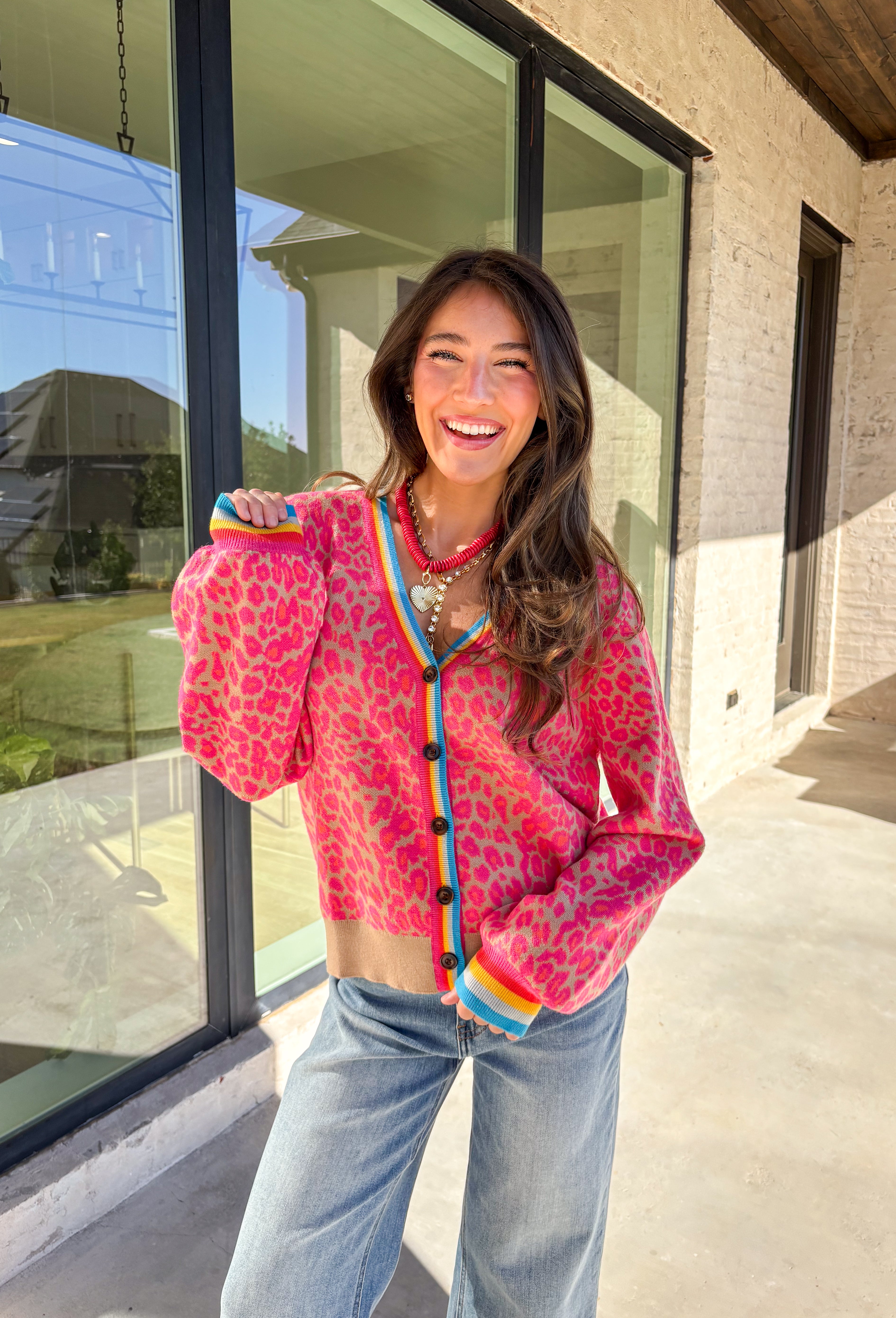 Get ready to turn heads and break up those neutral fall layers with a pop of wild color. This button-down leopard cardigan takes cozy to the next level with its bold pink print on a soft tan background—perfect for making your everyday denim look feel instantly exciting. The colorful trim adds even more personality, making this the ultimate statement layering piece.