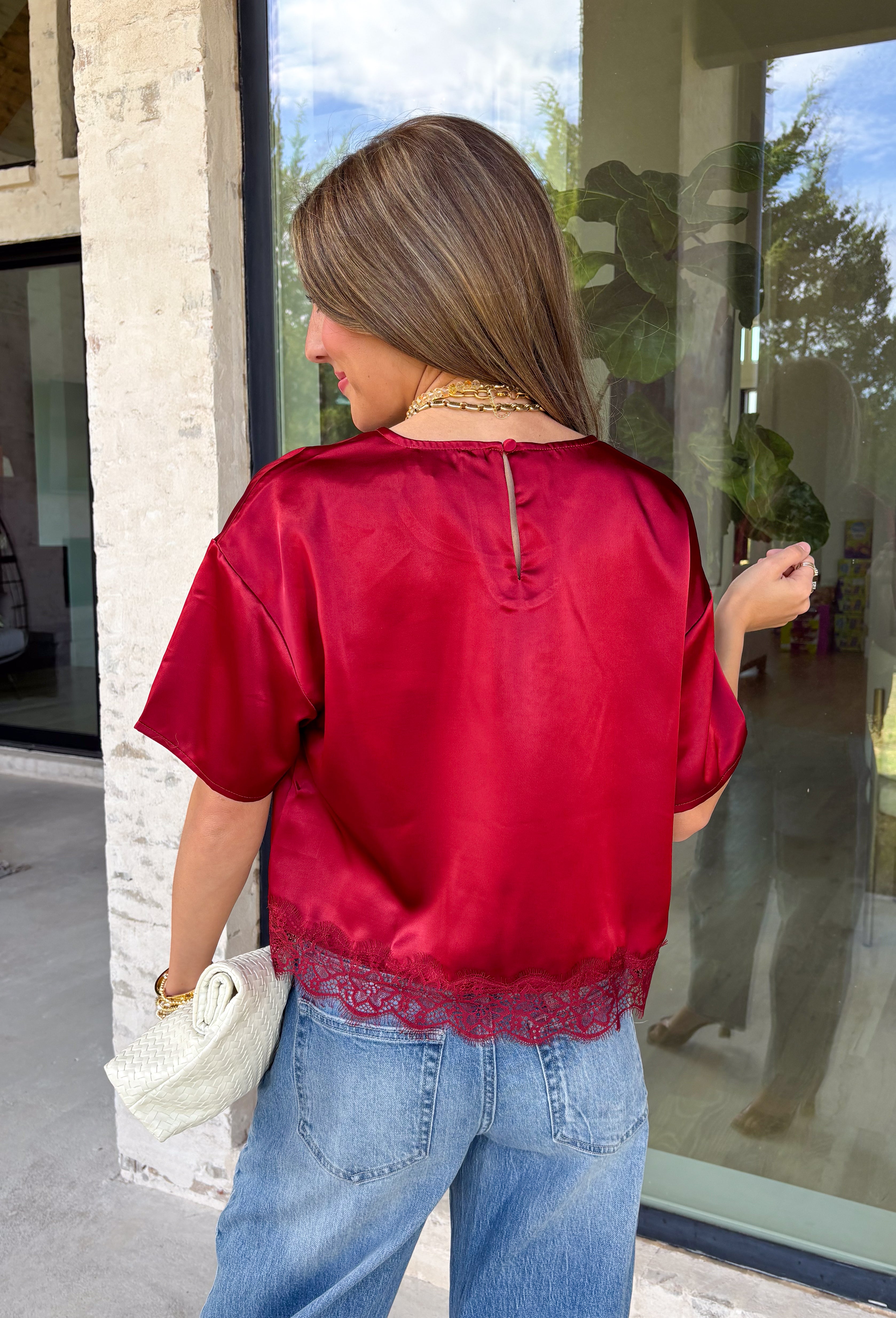 A rich red satin gives this short sleeve top from Sunday Edition the perfect festive feel for the holiday season. The smooth fabric adds a pretty touch of shine, while the lace hem brings in a soft detail that dresses up the simple silhouette. A keyhole opening at the back adds a finishing touch without taking away from the easy-to-style design. It’s a fun option for everything from Christmas parties and holiday dinners to festive date nights and seasonal get-togethers. 