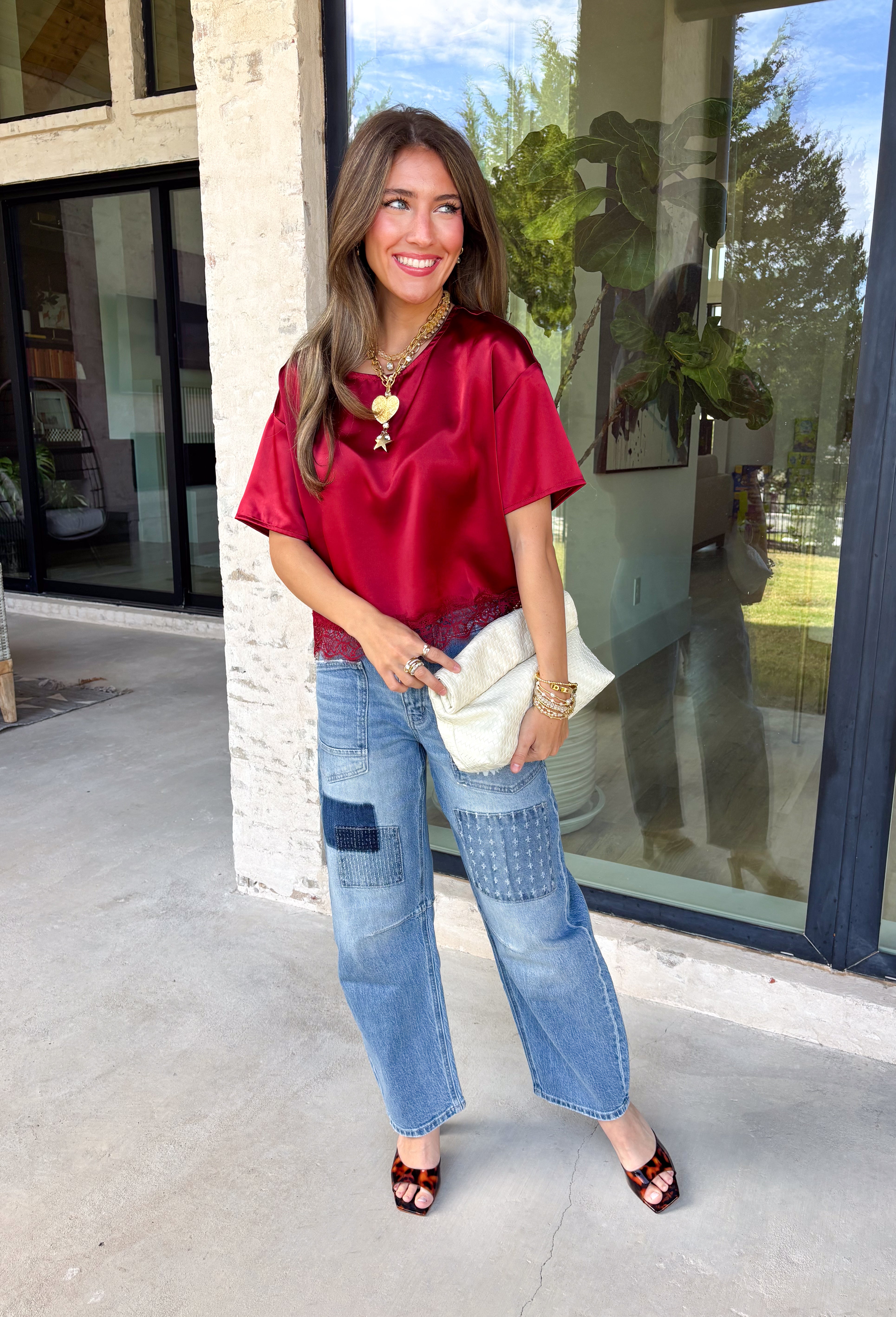 A rich red satin gives this short sleeve top from Sunday Edition the perfect festive feel for the holiday season. The smooth fabric adds a pretty touch of shine, while the lace hem brings in a soft detail that dresses up the simple silhouette. A keyhole opening at the back adds a finishing touch without taking away from the easy-to-style design. It’s a fun option for everything from Christmas parties and holiday dinners to festive date nights and seasonal get-togethers. 