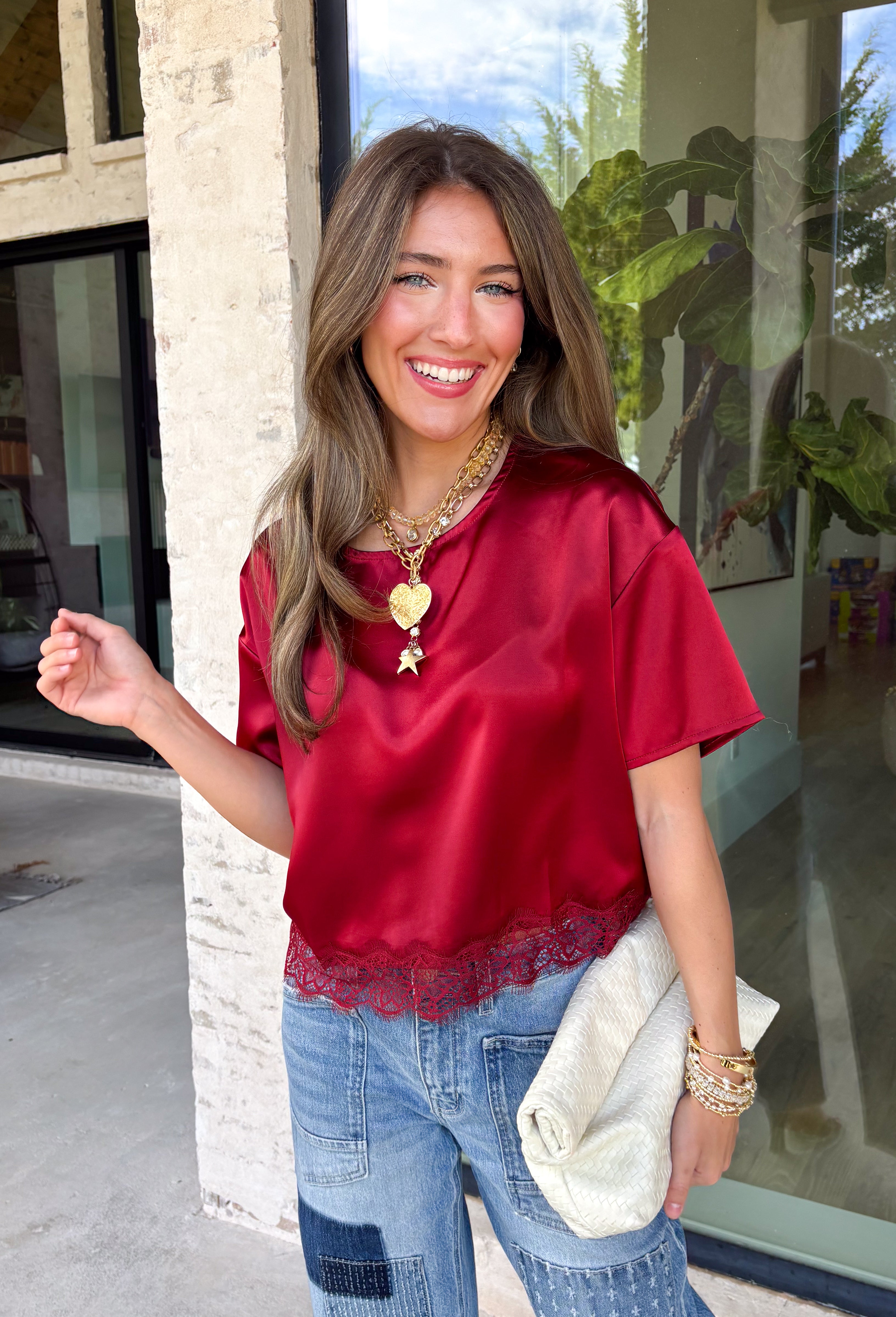 A rich red satin gives this short sleeve top from Sunday Edition the perfect festive feel for the holiday season. The smooth fabric adds a pretty touch of shine, while the lace hem brings in a soft detail that dresses up the simple silhouette. A keyhole opening at the back adds a finishing touch without taking away from the easy-to-style design. It’s a fun option for everything from Christmas parties and holiday dinners to festive date nights and seasonal get-togethers. 