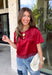 A rich red satin gives this short sleeve top from Sunday Edition the perfect festive feel for the holiday season. The smooth fabric adds a pretty touch of shine, while the lace hem brings in a soft detail that dresses up the simple silhouette. A keyhole opening at the back adds a finishing touch without taking away from the easy-to-style design. It’s a fun option for everything from Christmas parties and holiday dinners to festive date nights and seasonal get-togethers. 