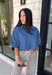 A classic denim top is a staple you'll reach for season after season! Crafted from soft medium wash denim, this effortless button-down blouse is designed with relaxed dolman sleeves and a subtle high-low hem for an easy, flattering fit. The collared neckline adds a timeless touch, making it simple to dress up or keep casual. Whether you're layering it under a blazer or wearing it on its own with your favorite fall denim, this versatile piece belongs in every autumn wardrobe.