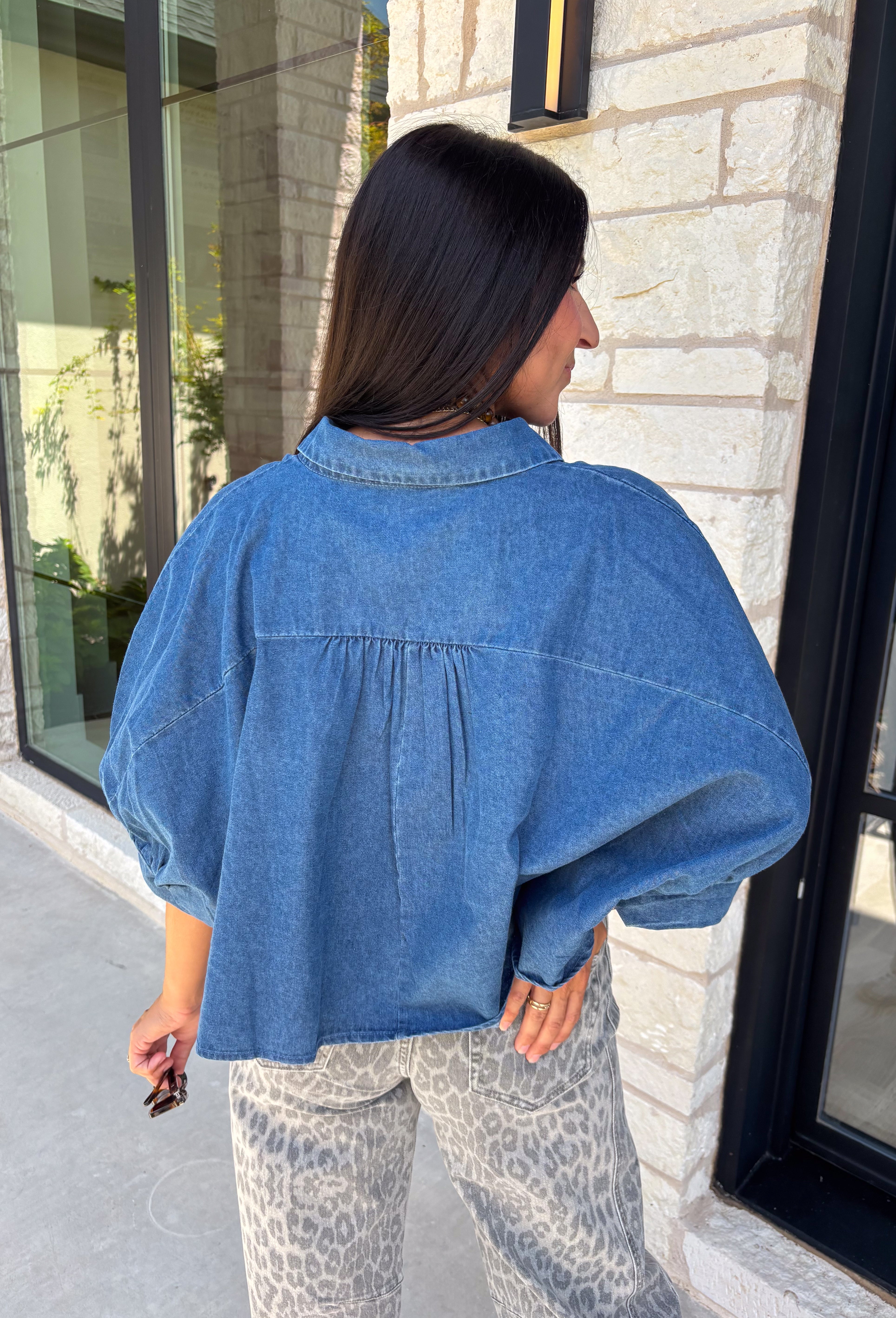 A classic denim top is a staple you'll reach for season after season! Crafted from soft medium wash denim, this effortless button-down blouse is designed with relaxed dolman sleeves and a subtle high-low hem for an easy, flattering fit. The collared neckline adds a timeless touch, making it simple to dress up or keep casual. Whether you're layering it under a blazer or wearing it on its own with your favorite fall denim, this versatile piece belongs in every autumn wardrobe.