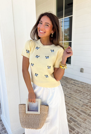 Soft, cheerful, and made for sunny days! This butter yellow ribbed sweater features the prettiest blue embroidered floral print that adds a fresh pop of color to your everyday look. The ribbed texture gives it a flattering, easy fit while the delicate embroidery brings in that sweet, spring-ready feel.Lightweight and comfortable, this short sleeve sweater is perfect for transitioning between seasons. 