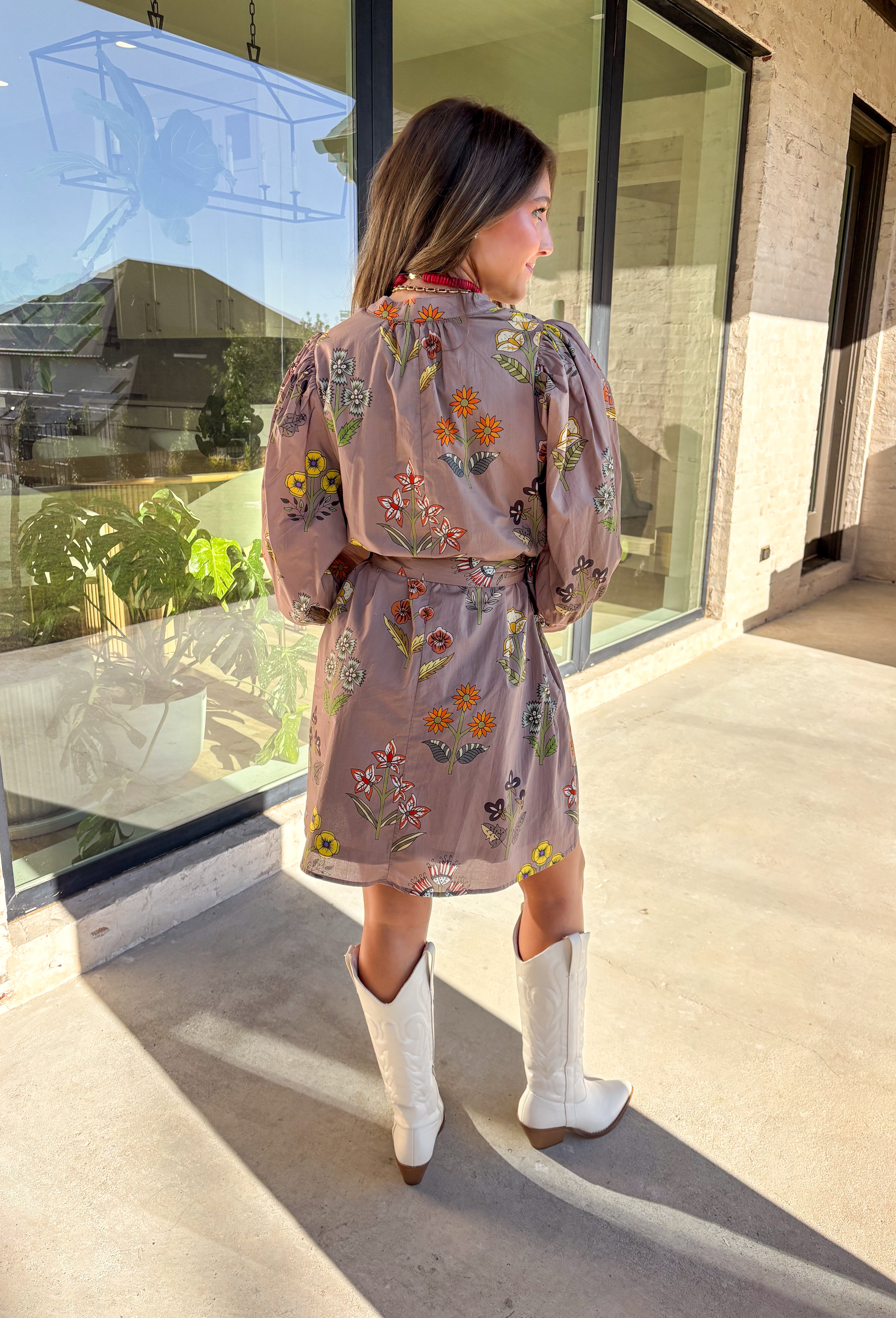 This mocha long sleeve dress by Entro captures all the warmth and charm of fall. Featuring a botanical floral print in rich autumn shades, it’s designed with a flattering v-neckline and a self-tie belt to define the waist. Side pockets and a full lining make it as practical as it is stylish, while the soft cotton fabric keeps it comfortable all day long. A perfect go-to for weekend plans, fall photos, or seasonal get-togethers.