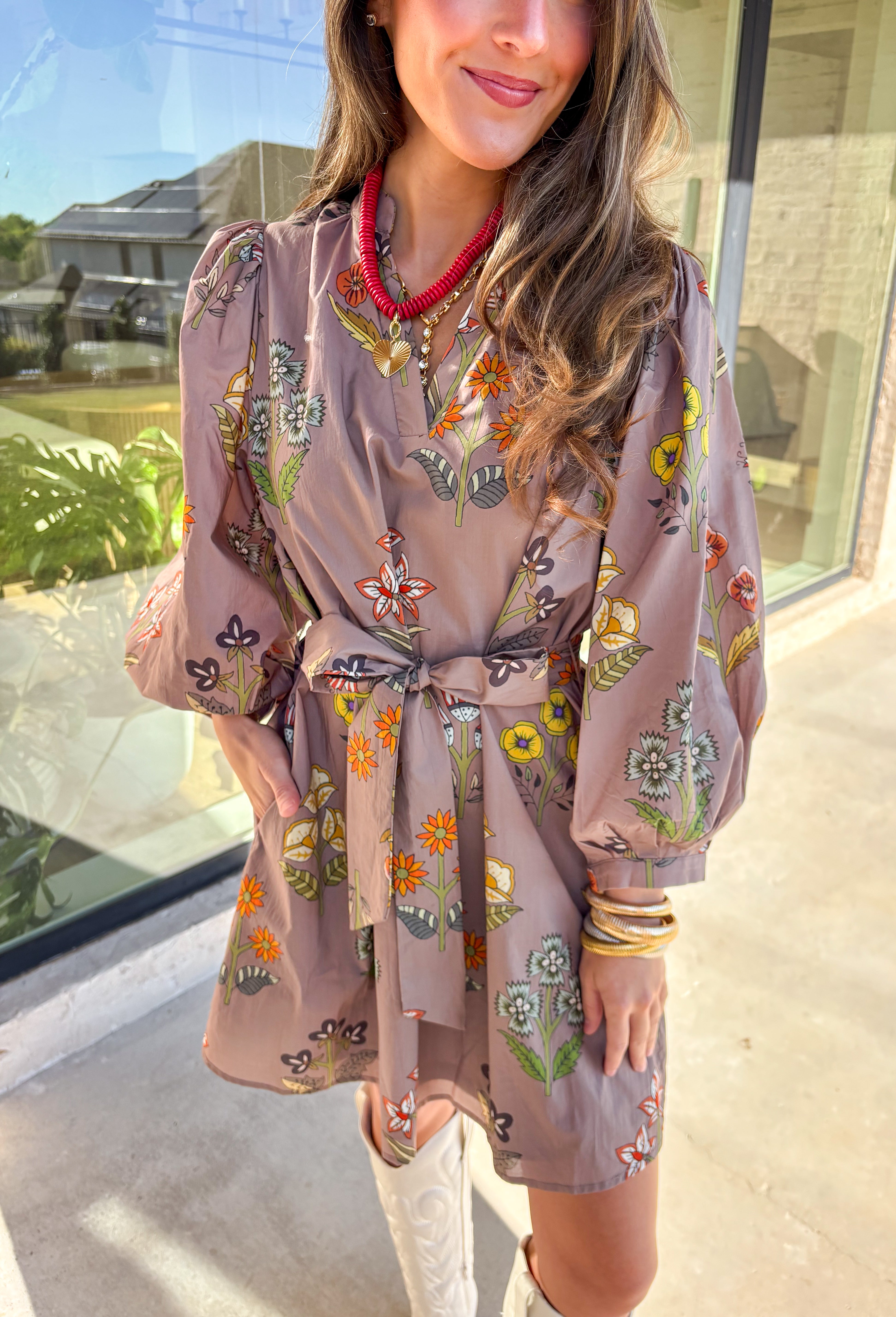 This mocha long sleeve dress by Entro captures all the warmth and charm of fall. Featuring a botanical floral print in rich autumn shades, it’s designed with a flattering v-neckline and a self-tie belt to define the waist. Side pockets and a full lining make it as practical as it is stylish, while the soft cotton fabric keeps it comfortable all day long. A perfect go-to for weekend plans, fall photos, or seasonal get-togethers.