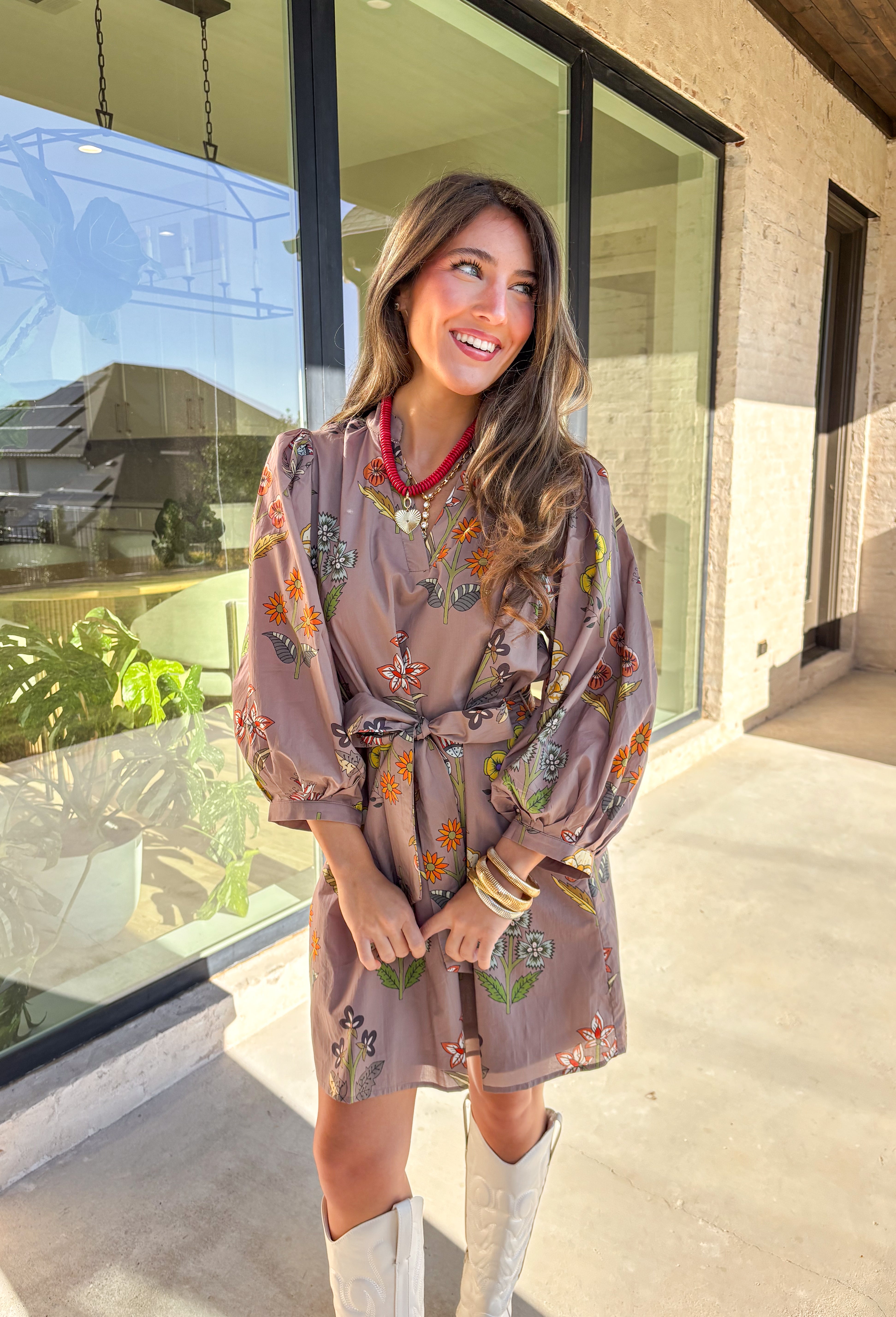 This mocha long sleeve dress by Entro captures all the warmth and charm of fall. Featuring a botanical floral print in rich autumn shades, it’s designed with a flattering v-neckline and a self-tie belt to define the waist. Side pockets and a full lining make it as practical as it is stylish, while the soft cotton fabric keeps it comfortable all day long. A perfect go-to for weekend plans, fall photos, or seasonal get-togethers.
