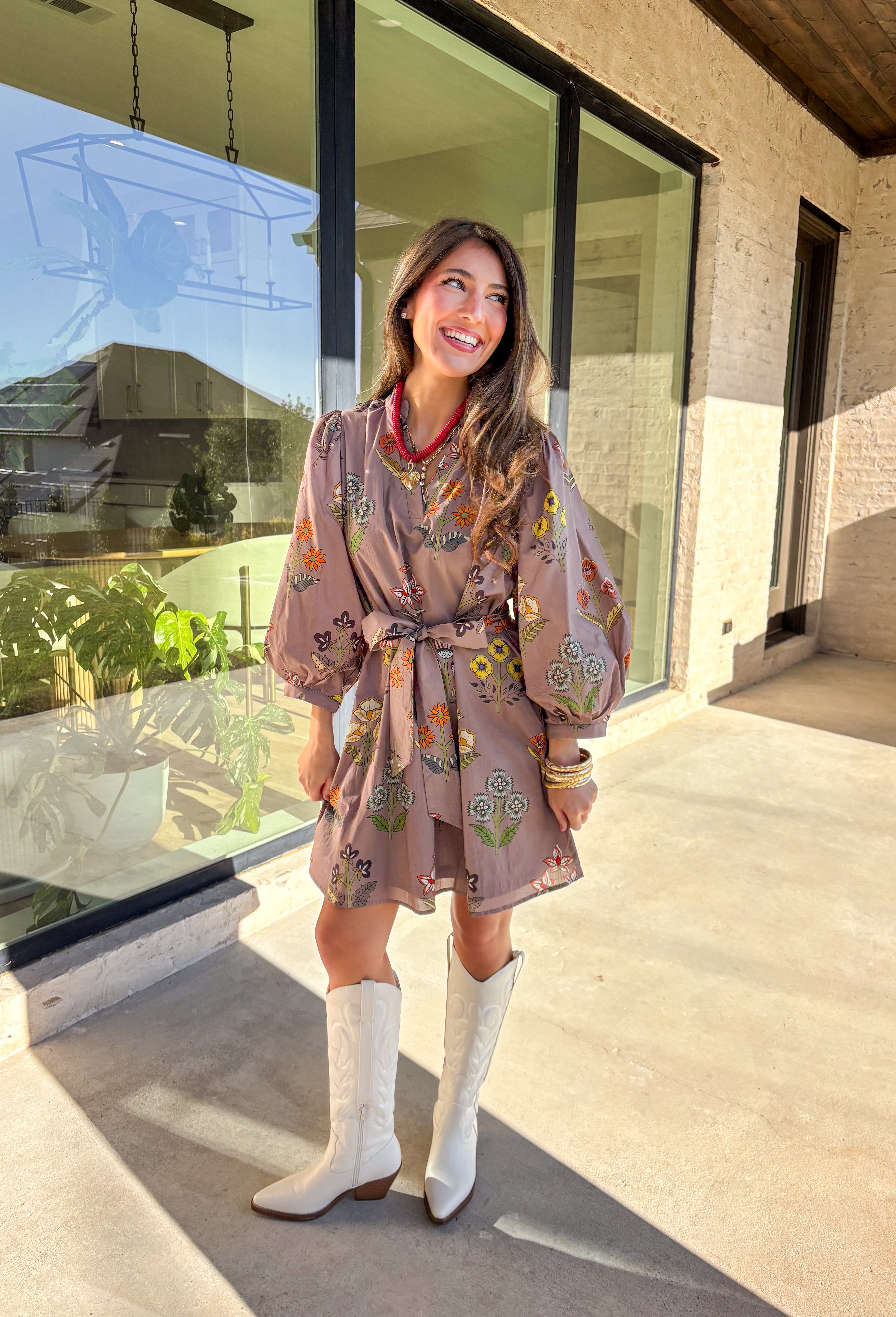 This mocha long sleeve dress by Entro captures all the warmth and charm of fall. Featuring a botanical floral print in rich autumn shades, it’s designed with a flattering v-neckline and a self-tie belt to define the waist. Side pockets and a full lining make it as practical as it is stylish, while the soft cotton fabric keeps it comfortable all day long. A perfect go-to for weekend plans, fall photos, or seasonal get-togethers.
