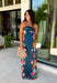 Make an unforgettable entrance in this stunning satin midi dress! The rich dark teal color creates the perfect backdrop for the vibrant floral print that blooms along each side in shades of pink, purple, green, yellow, red, and blue. The strapless neckline gives it an effortlessly elegant feel, while the smooth satin fabric adds a beautiful touch of shine. 