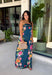 Make an unforgettable entrance in this stunning satin midi dress! The rich dark teal color creates the perfect backdrop for the vibrant floral print that blooms along each side in shades of pink, purple, green, yellow, red, and blue. The strapless neckline gives it an effortlessly elegant feel, while the smooth satin fabric adds a beautiful touch of shine. 