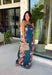 Make an unforgettable entrance in this stunning satin midi dress! The rich dark teal color creates the perfect backdrop for the vibrant floral print that blooms along each side in shades of pink, purple, green, yellow, red, and blue. The strapless neckline gives it an effortlessly elegant feel, while the smooth satin fabric adds a beautiful touch of shine. 