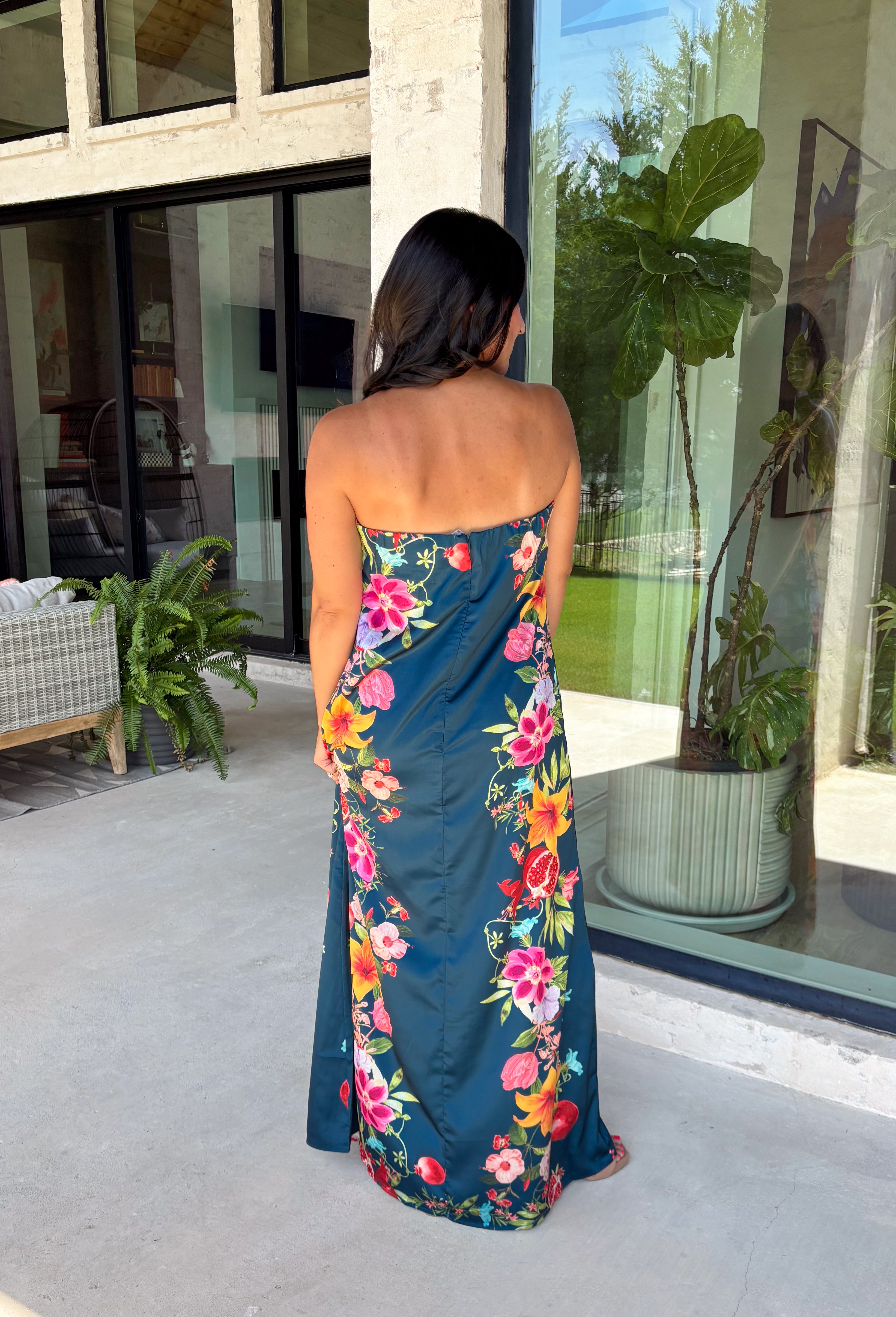 Make an unforgettable entrance in this stunning satin midi dress! The rich dark teal color creates the perfect backdrop for the vibrant floral print that blooms along each side in shades of pink, purple, green, yellow, red, and blue. The strapless neckline gives it an effortlessly elegant feel, while the smooth satin fabric adds a beautiful touch of shine. 