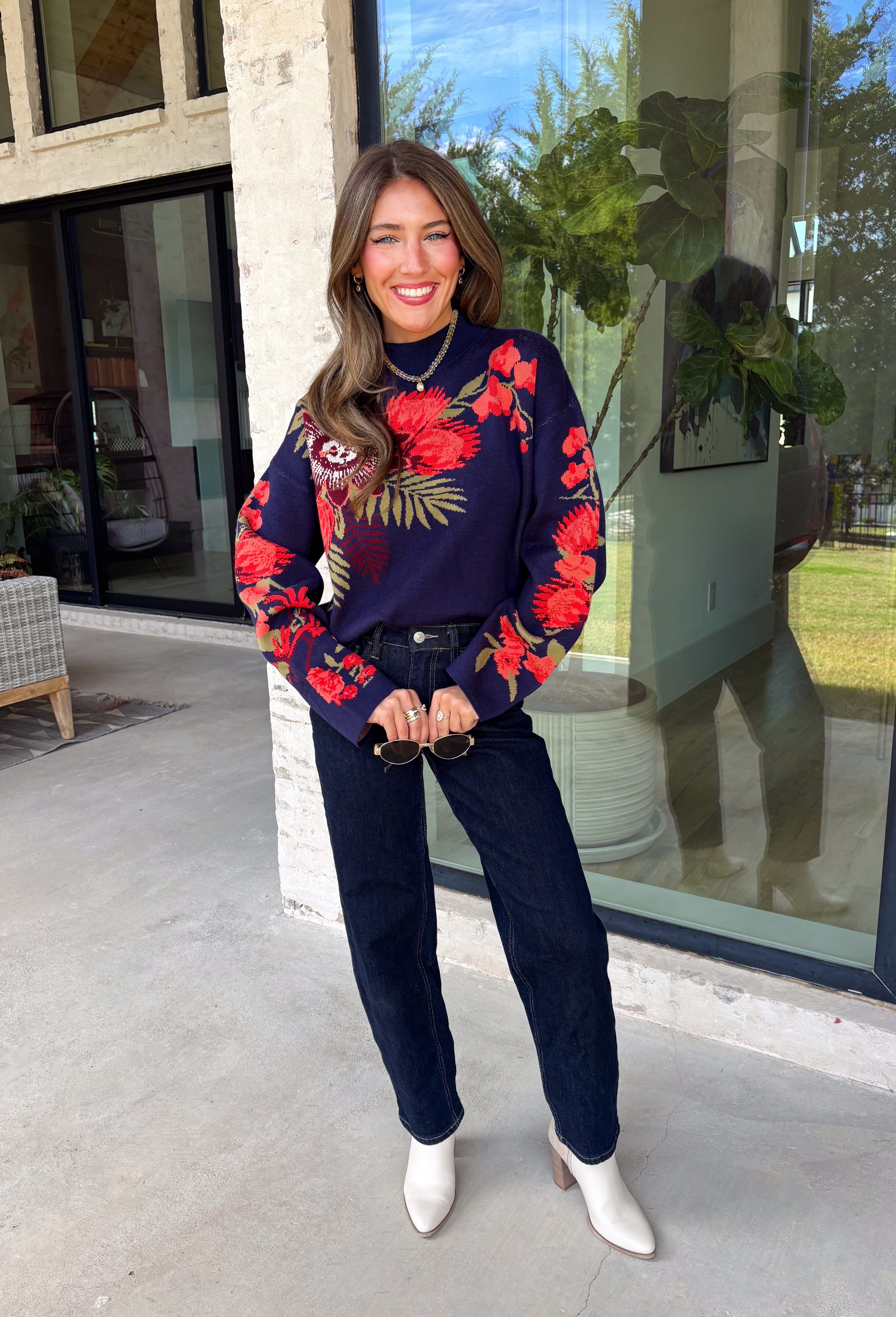 Wrap yourself in cozy comfort with a sweater that's bursting with beautiful seasonal color! This navy knit sweater is adorned with a vibrant floral motif featuring shades of coral, burgundy, olive green, and off white, creating the perfect blend of timeless charm and autumn style. The mock neckline and relaxed drop shoulders give it an effortlessly cozy feel, while the soft knit fabric makes it an easy choice for crisp mornings, weekend outings, and everything in between. 
