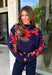Wrap yourself in cozy comfort with a sweater that's bursting with beautiful seasonal color! This navy knit sweater is adorned with a vibrant floral motif featuring shades of coral, burgundy, olive green, and off white, creating the perfect blend of timeless charm and autumn style. The mock neckline and relaxed drop shoulders give it an effortlessly cozy feel, while the soft knit fabric makes it an easy choice for crisp mornings, weekend outings, and everything in between. 