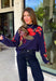 Wrap yourself in cozy comfort with a sweater that's bursting with beautiful seasonal color! This navy knit sweater is adorned with a vibrant floral motif featuring shades of coral, burgundy, olive green, and off white, creating the perfect blend of timeless charm and autumn style. The mock neckline and relaxed drop shoulders give it an effortlessly cozy feel, while the soft knit fabric makes it an easy choice for crisp mornings, weekend outings, and everything in between. 